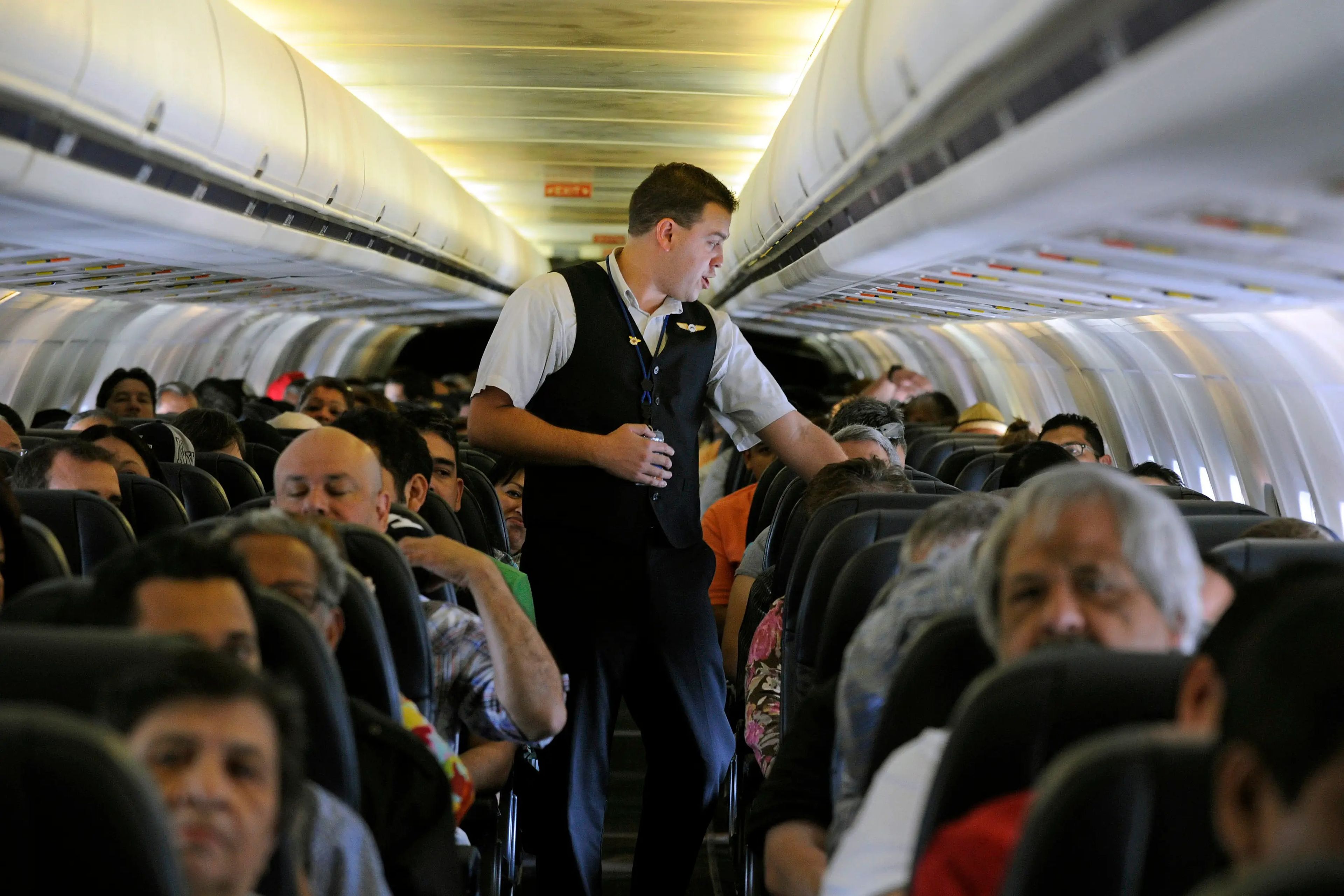 flight attendant walks through aisle