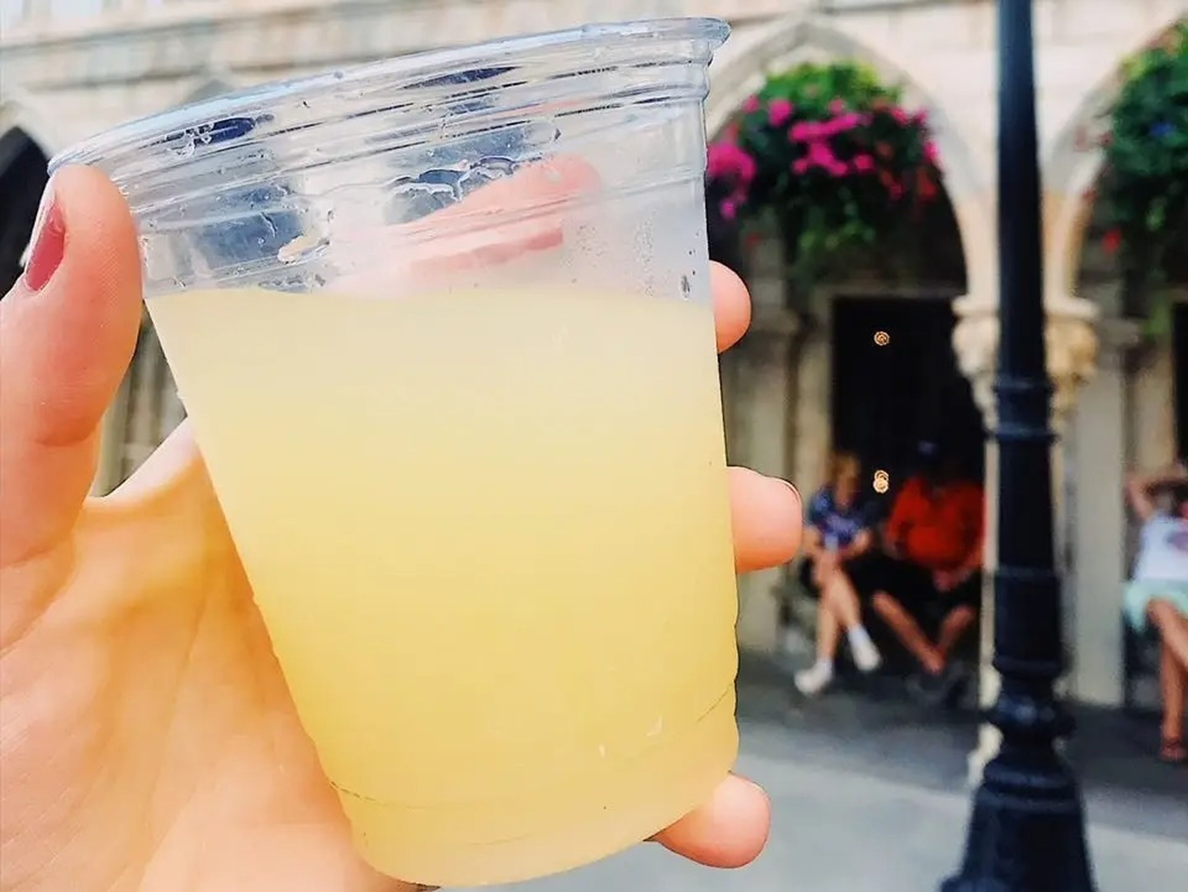 hand holding a yellow cocktail in epcot at disney world