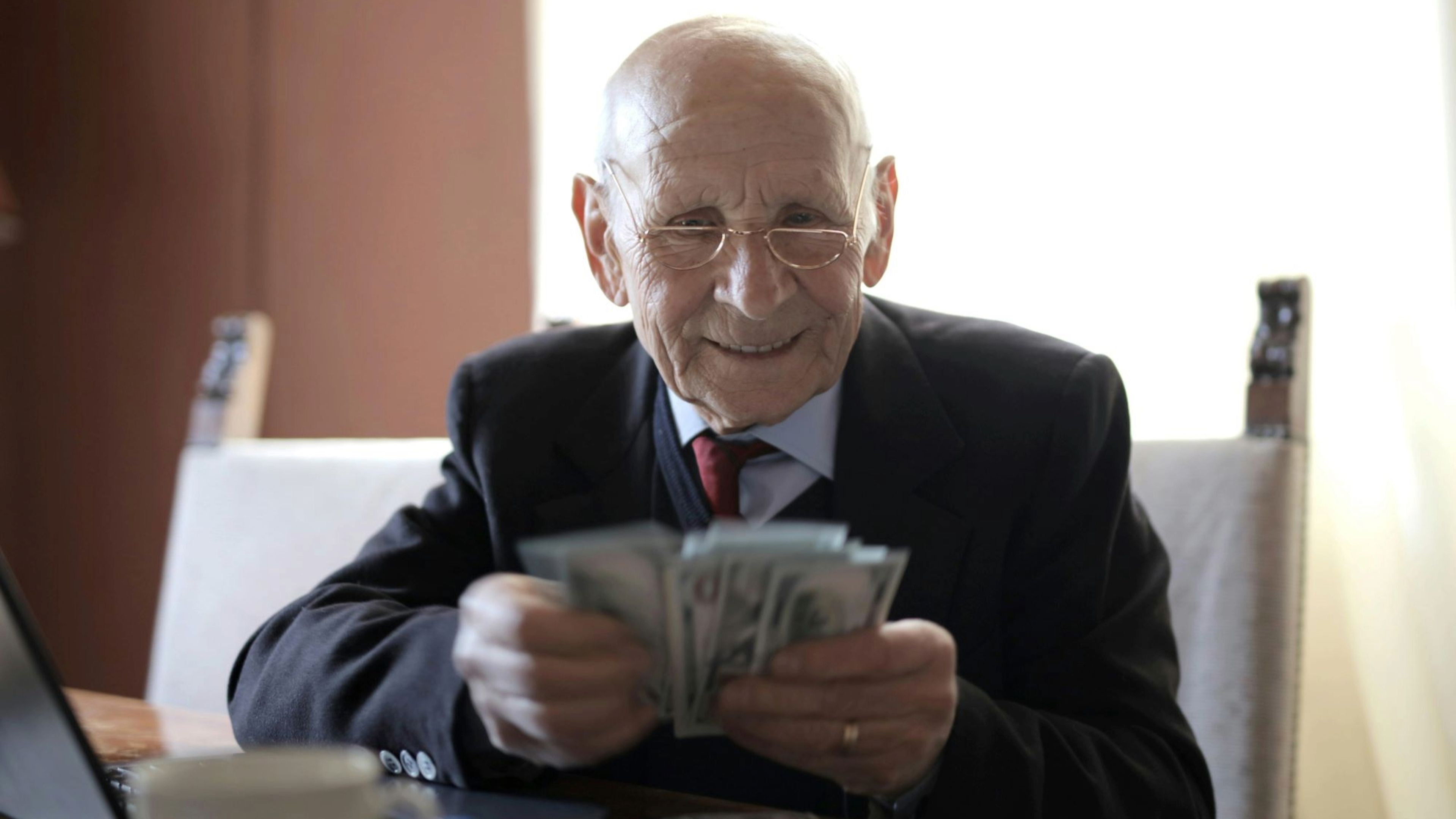 Hombre mayor, anciano, pensionista cuenta dinero