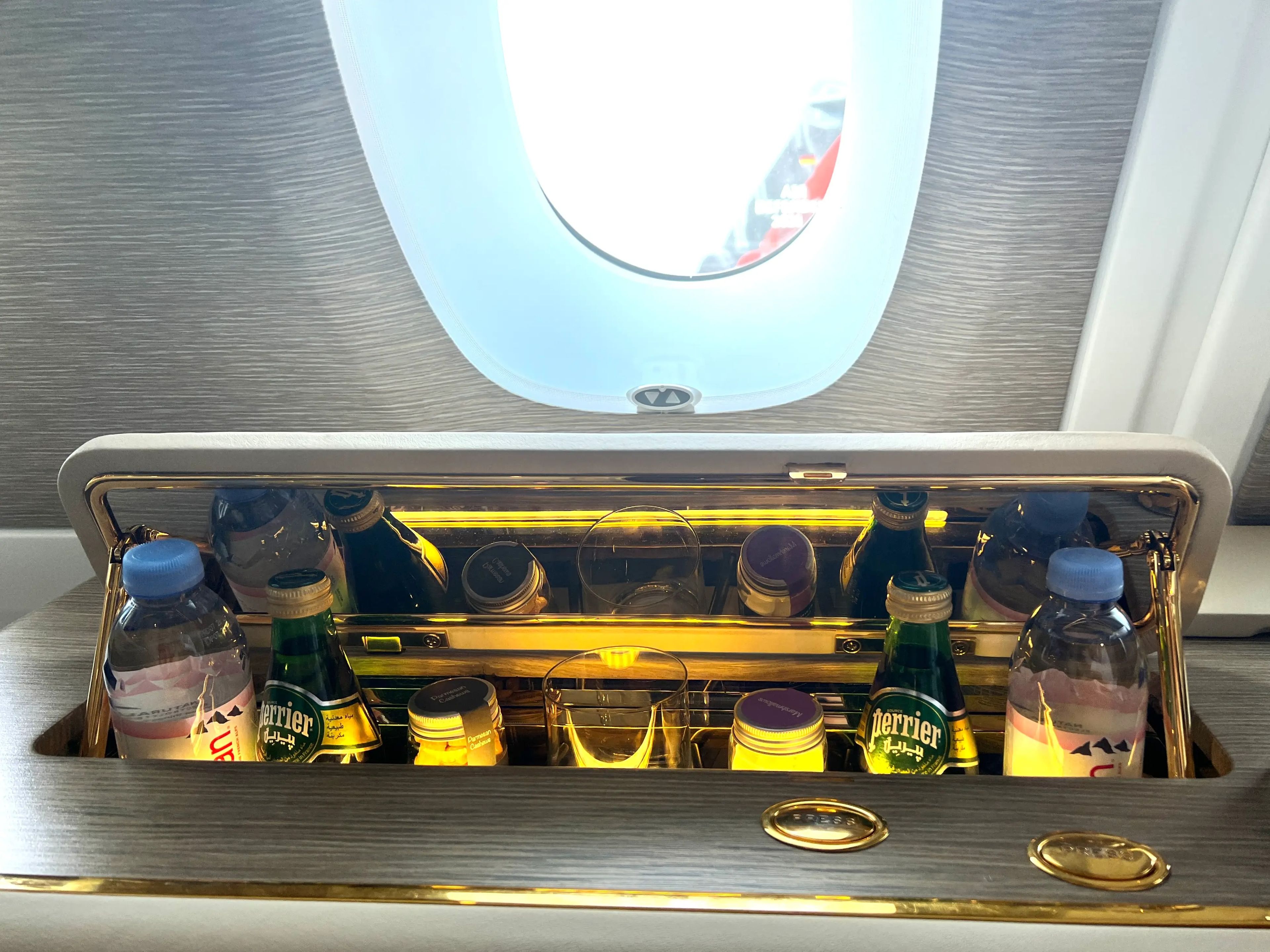 The pop-up minibar underneath the window in a first class suite on Emirates A380 includes still and sparkling water and nuts.