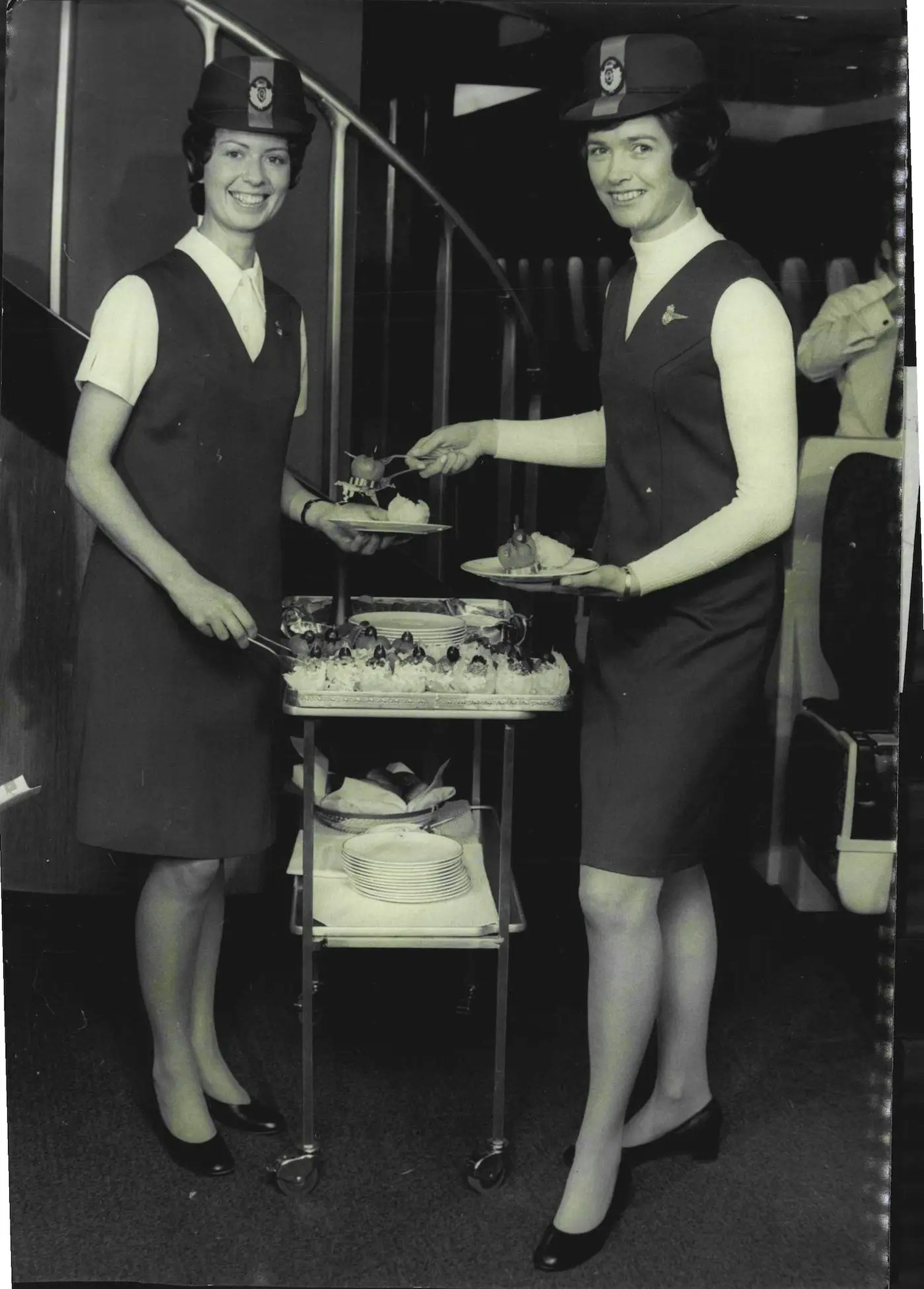 Dos auxiliares de vuelo de Qantas lucen los uniformes de la aerolínea en agosto de 1971.