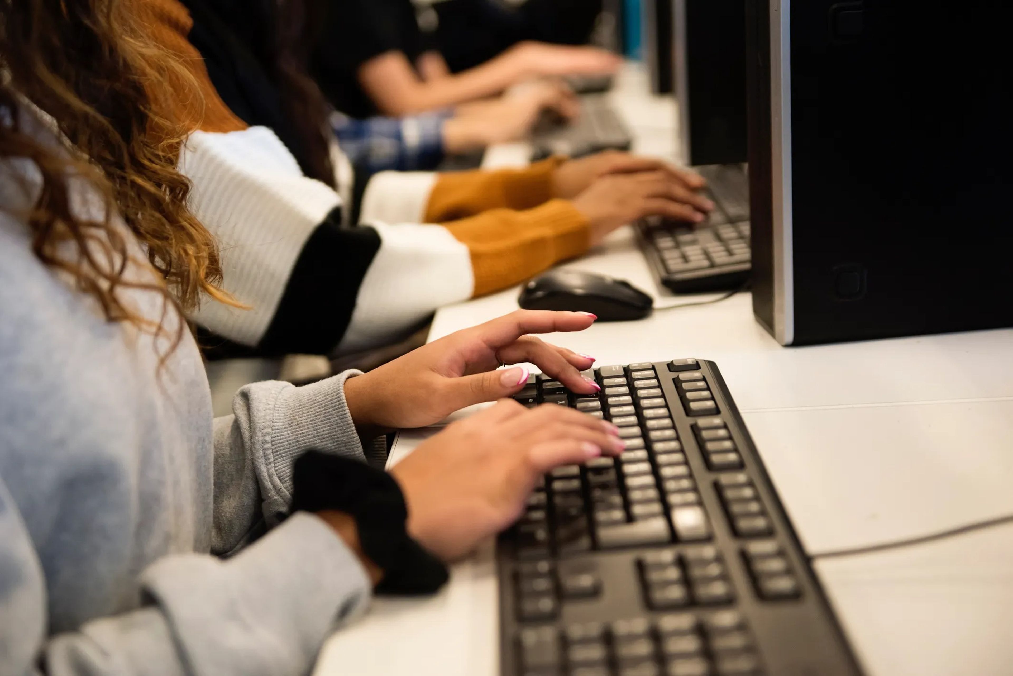 Trabajadores jóvenes tecleando en sus ordenadores.