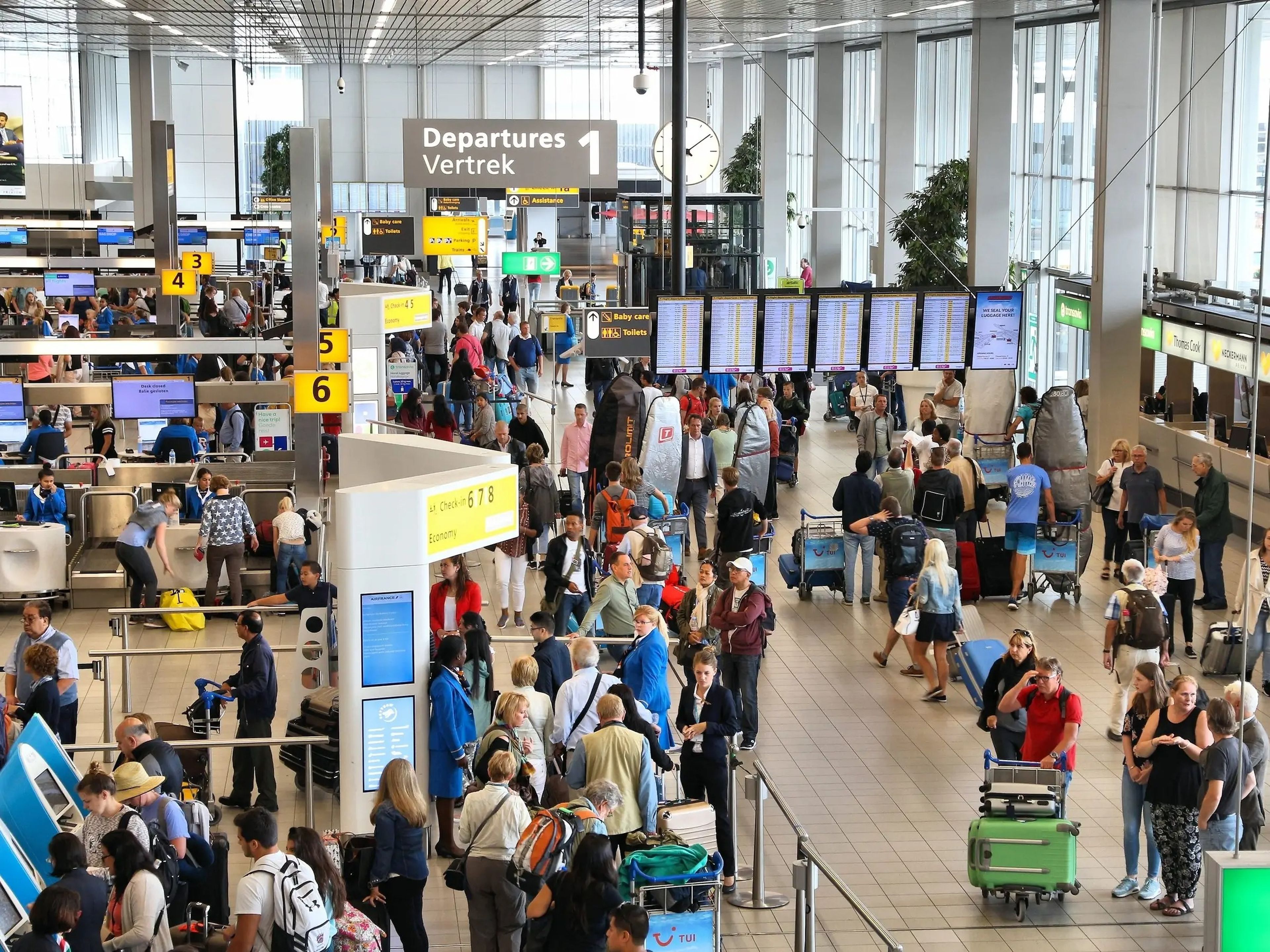 busy airport crowded with passengers checking in for flights