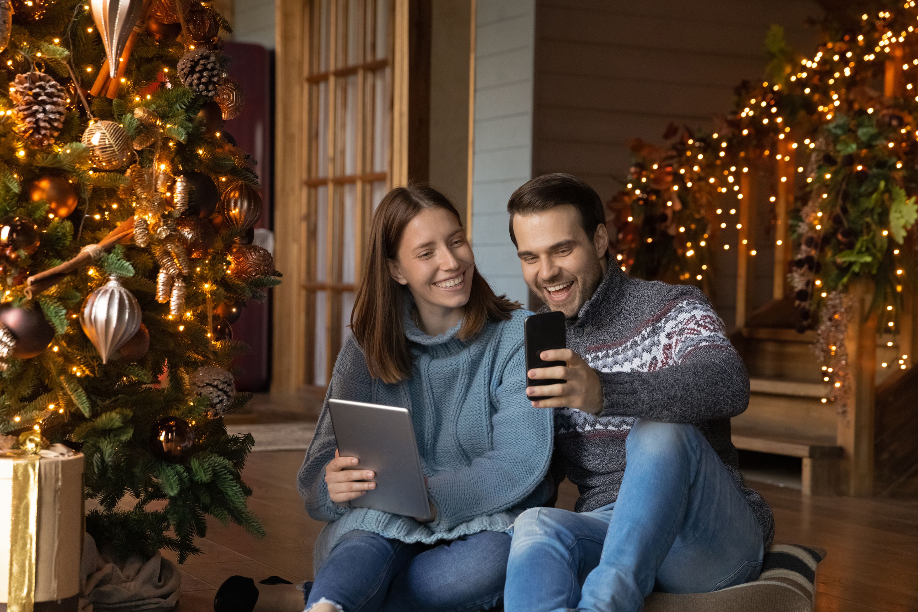Dos personas con el móvil disfrutando de la Navidad