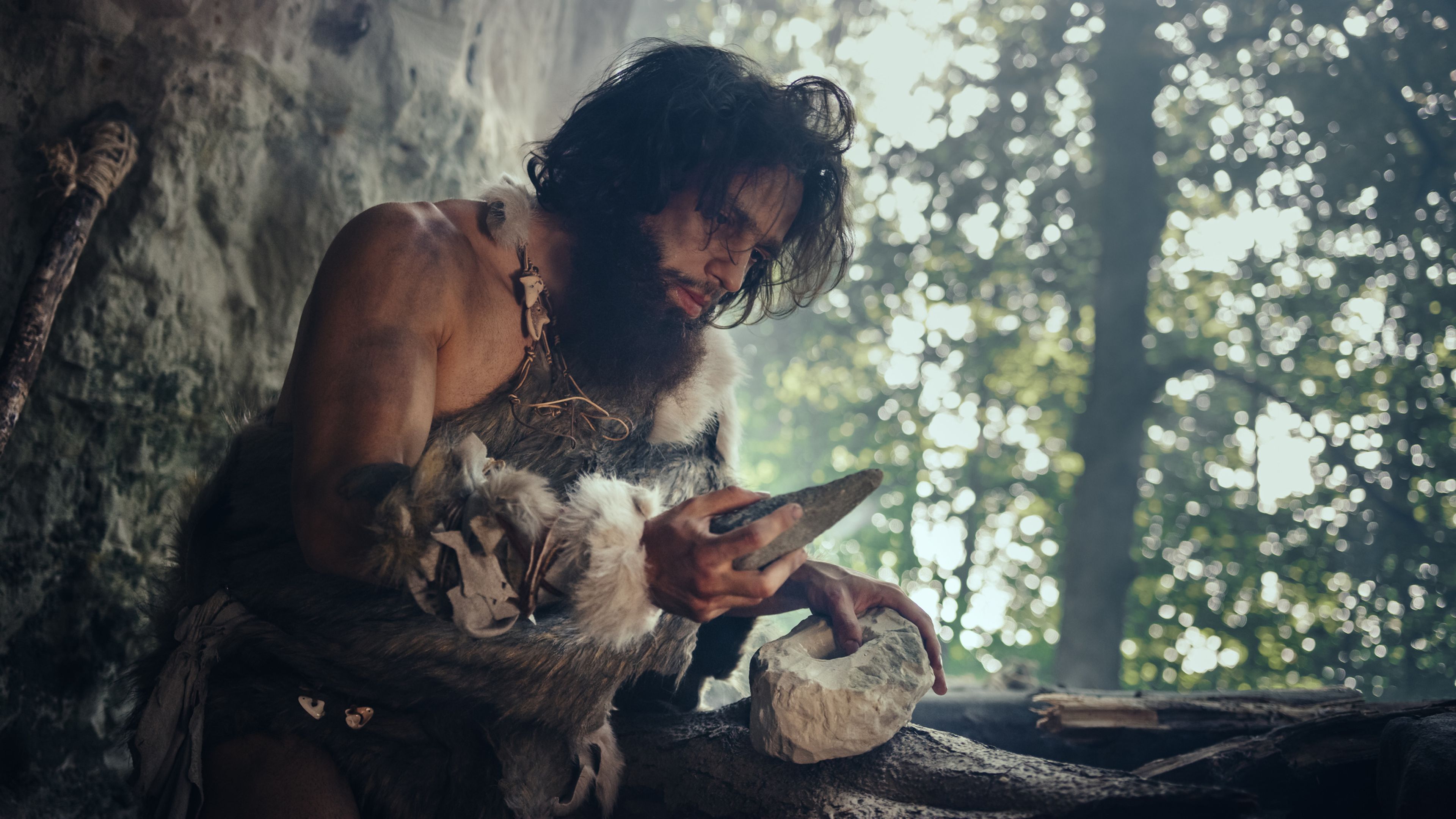Hombre neandertal afilando una cuchilla