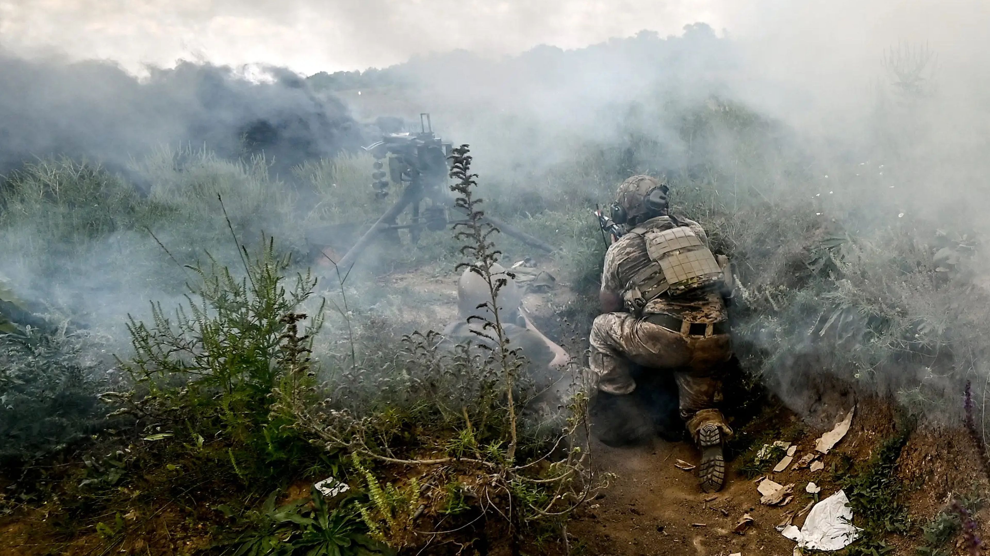 El humo cubre a los militares que practican el asalto a posiciones enemigas durante un simulacro táctico en la dirección de la provincia de Zaporiyia.