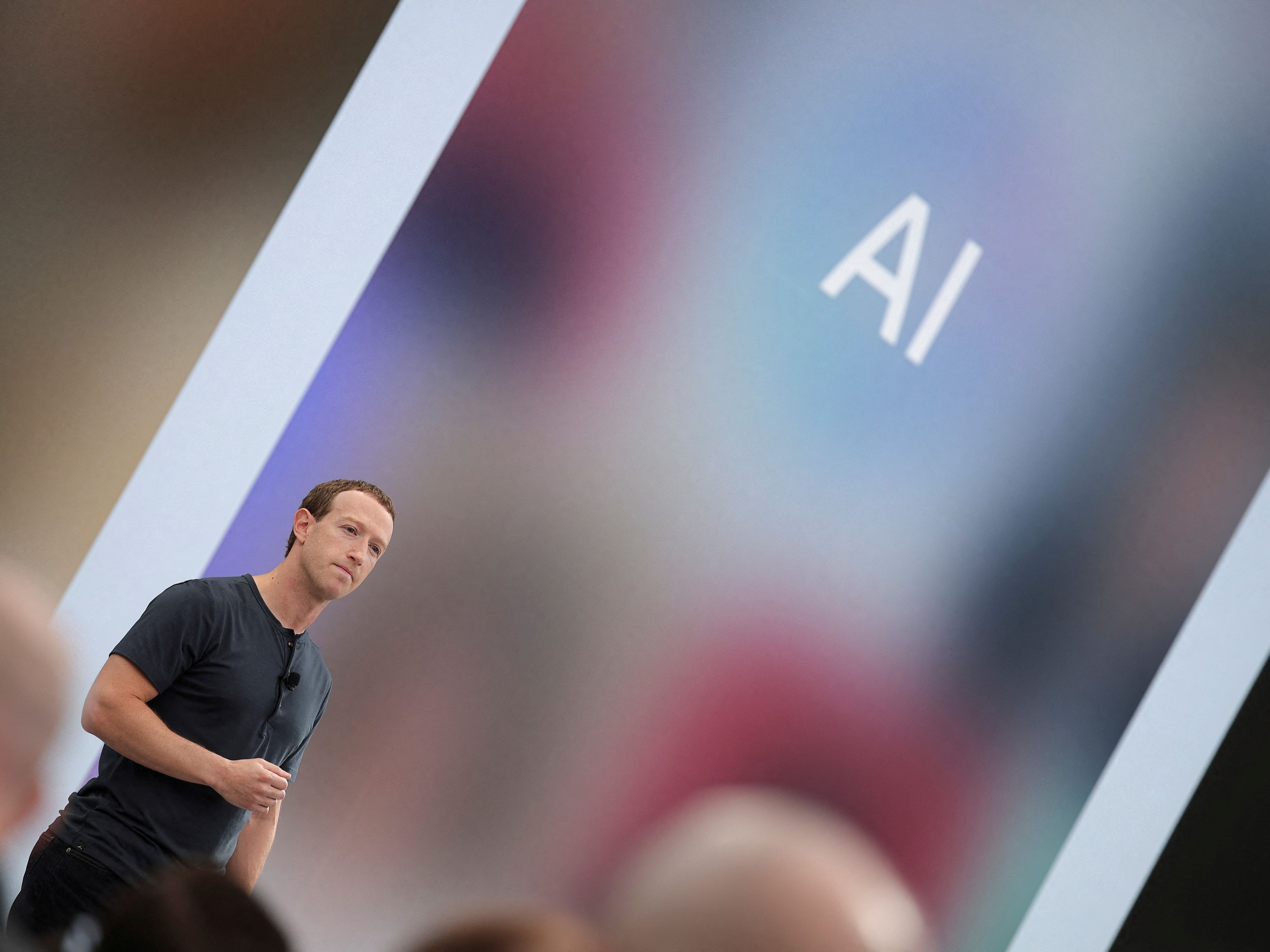 Mark Zuckerberg, CEO de Meta, pronuncia un discurso mientras aparecen en pantalla las letras AI de inteligencia artificial.