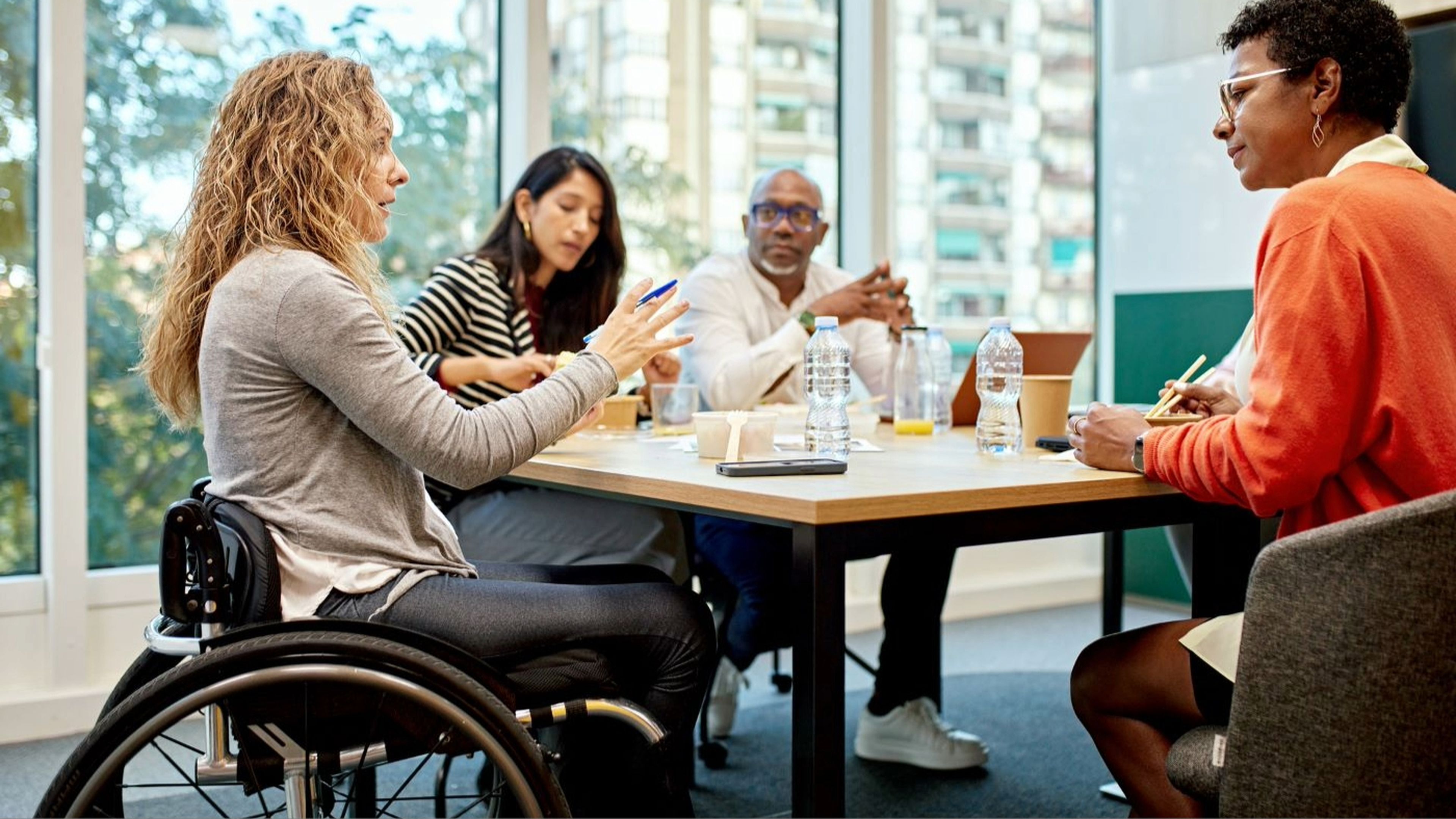 Mujer en silla de ruedas en una reunión de trabajo en la oficina