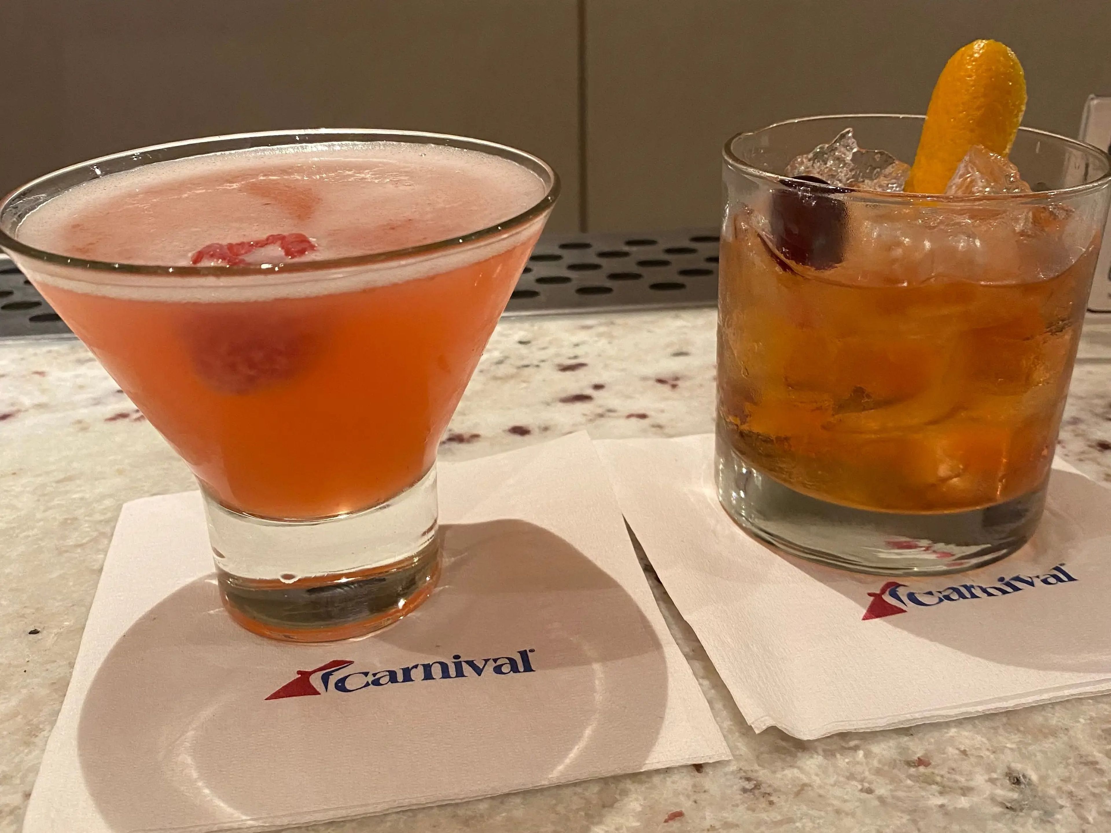 Two drinks on cocktail napkins on Carnival Elation