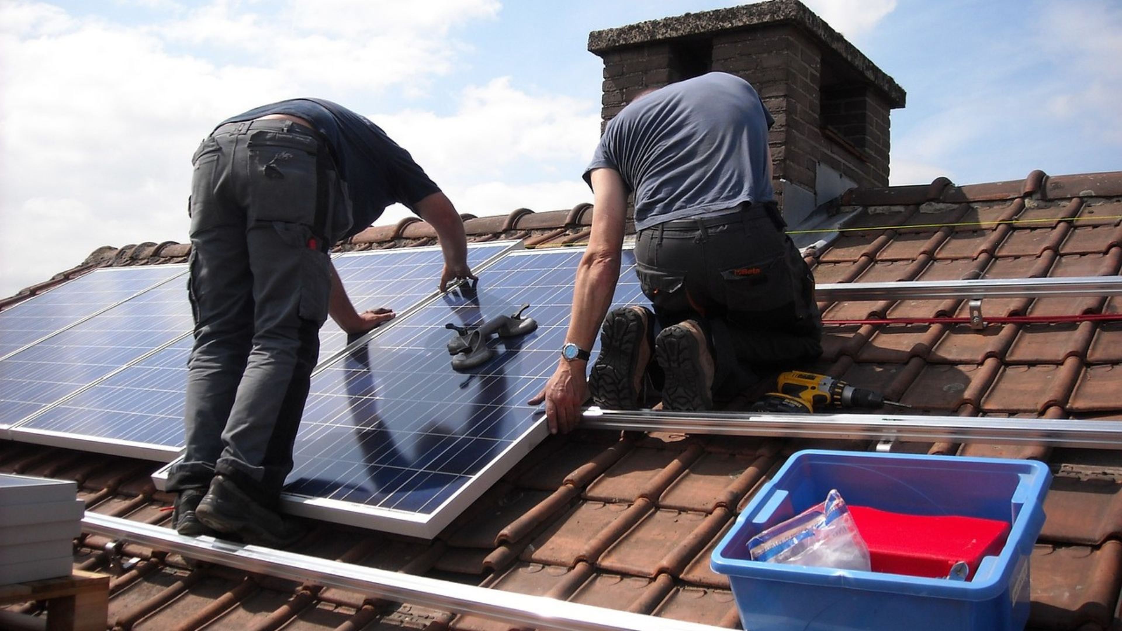 2 instaladores de placas solares en un tejado. 