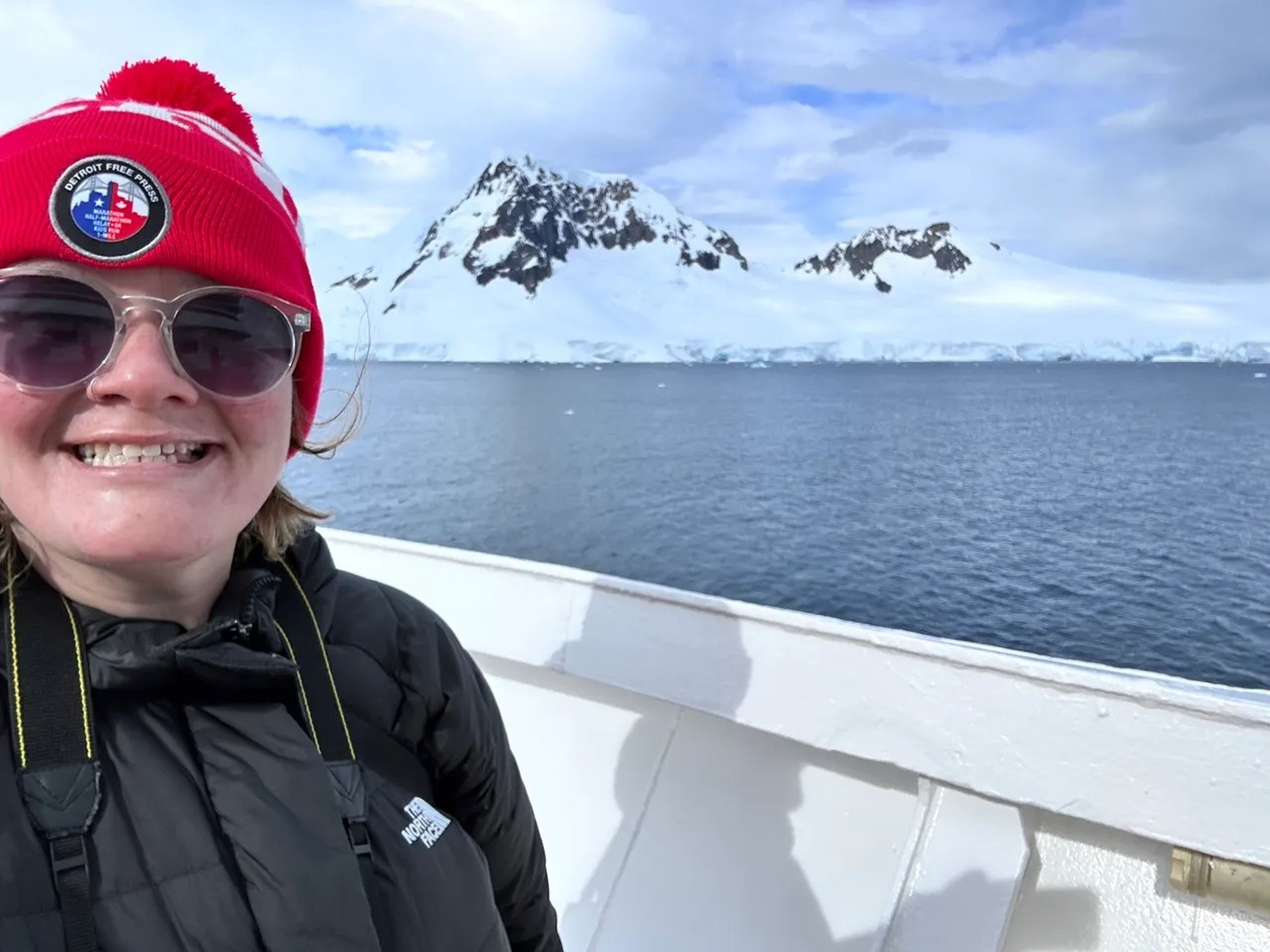 Author Erin Yarnall smiling on a cruise in front of a glacier