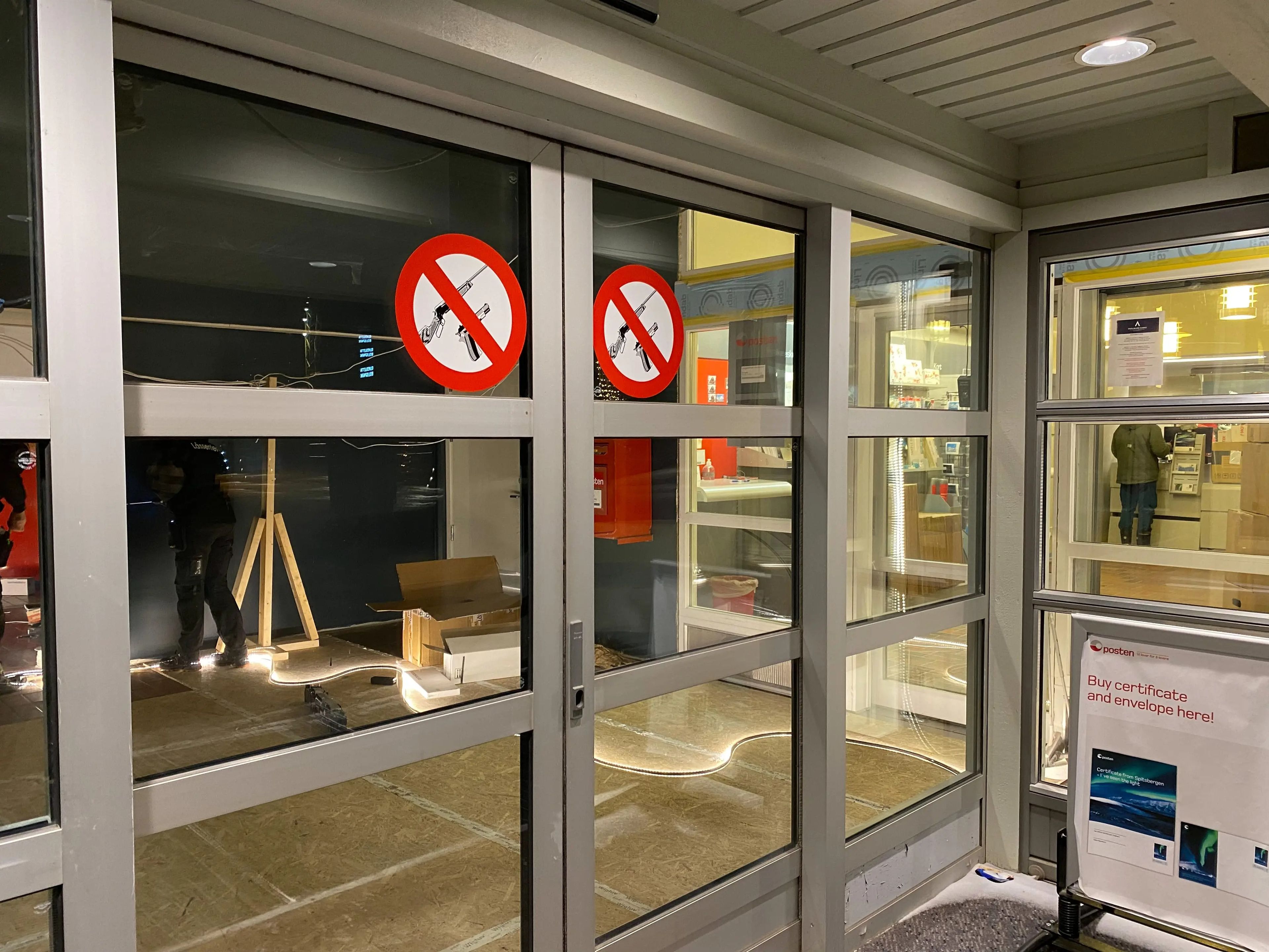 Automatic sliding doors with "no firearms" signs on them