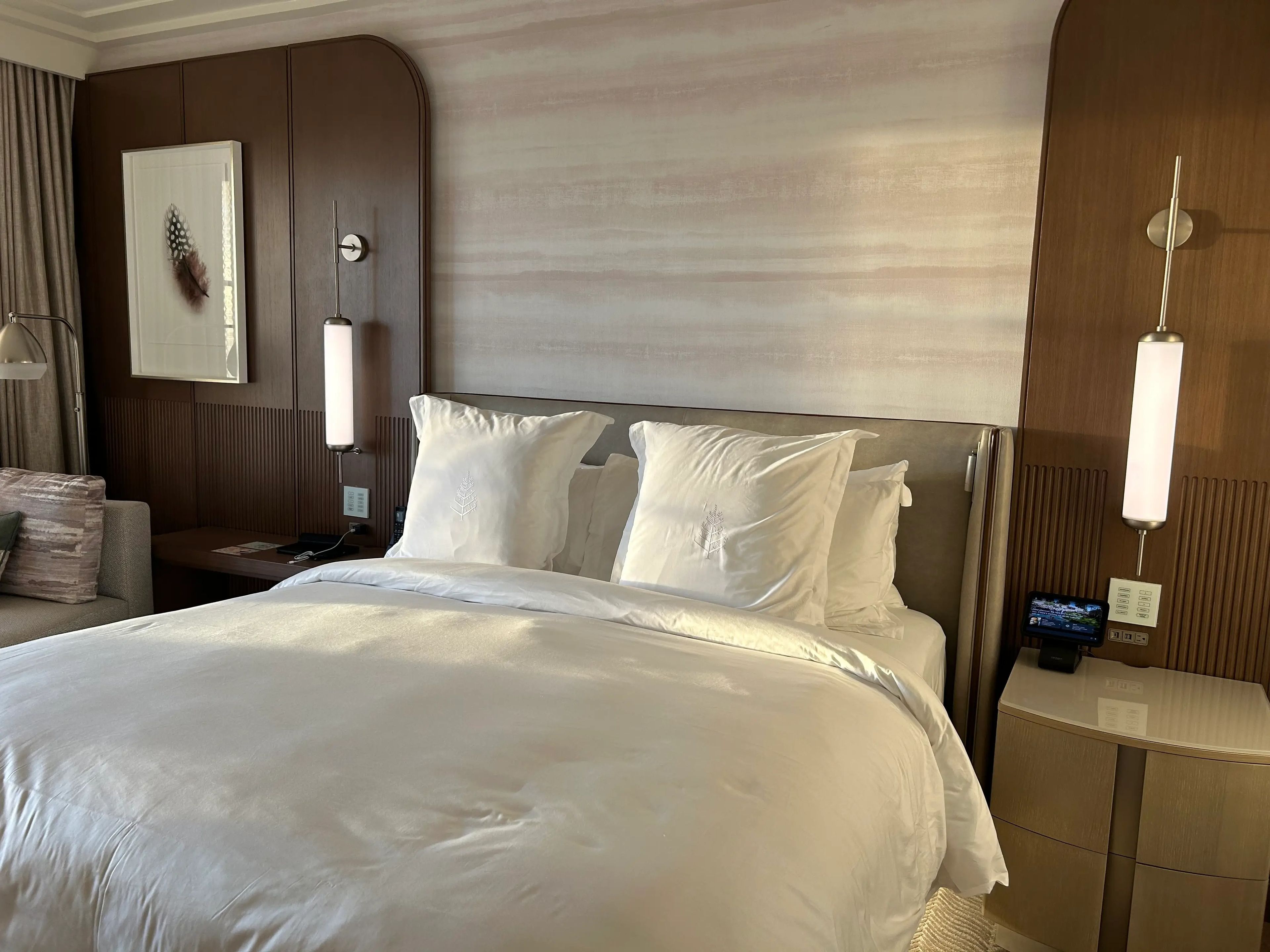 Disney World Four Seasons room with white bed and nightstands on either side 