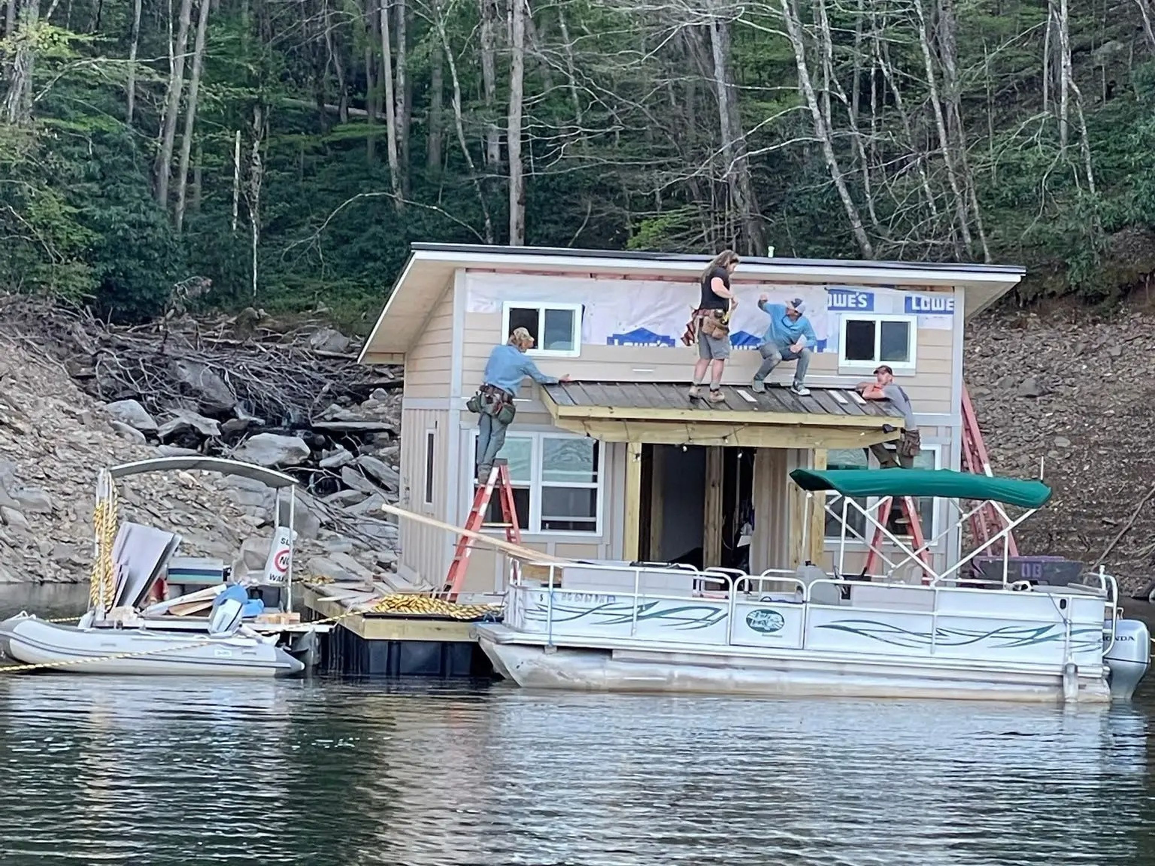 A few people standing on a floating home during its construction.