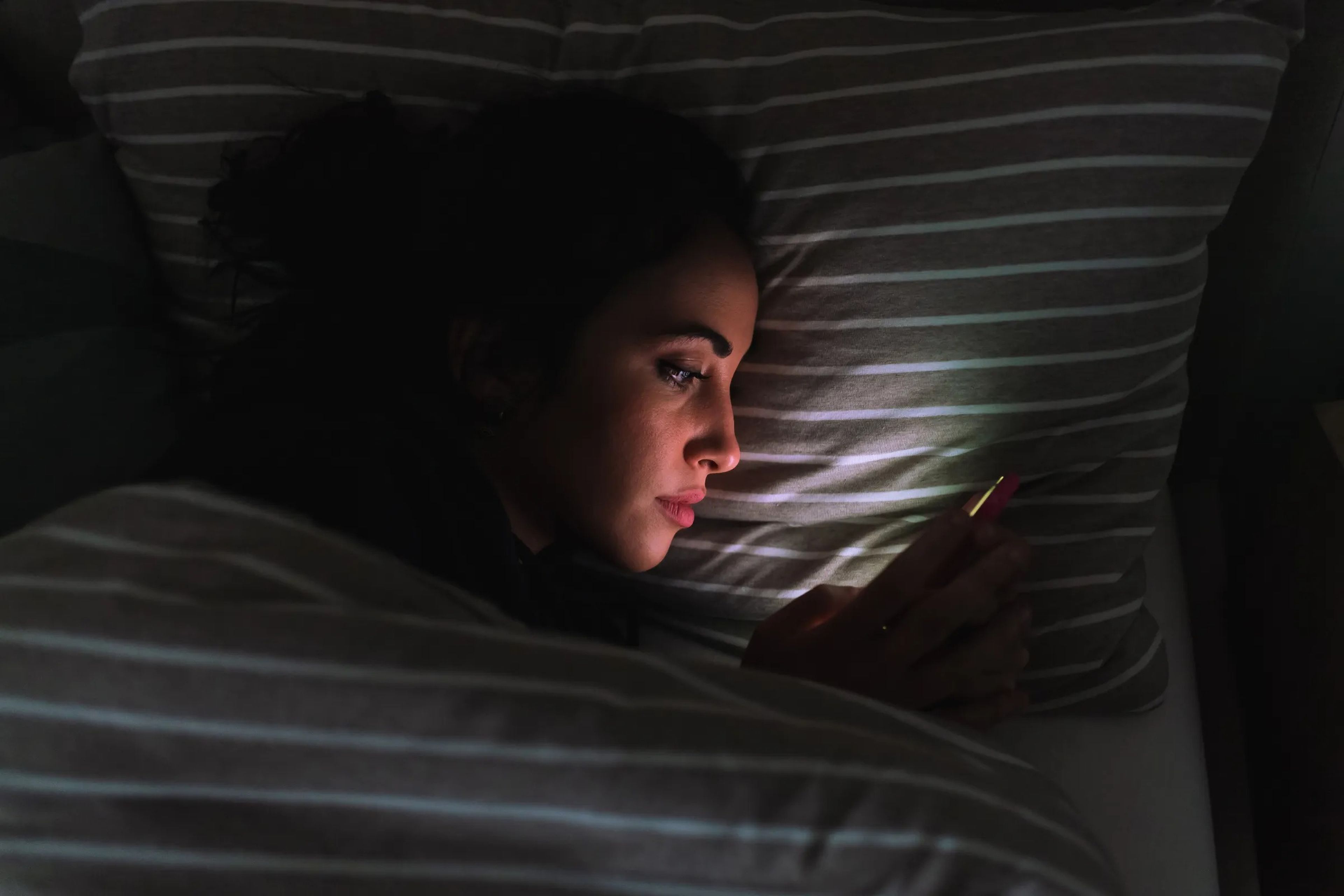 girl looking at her phone in bed