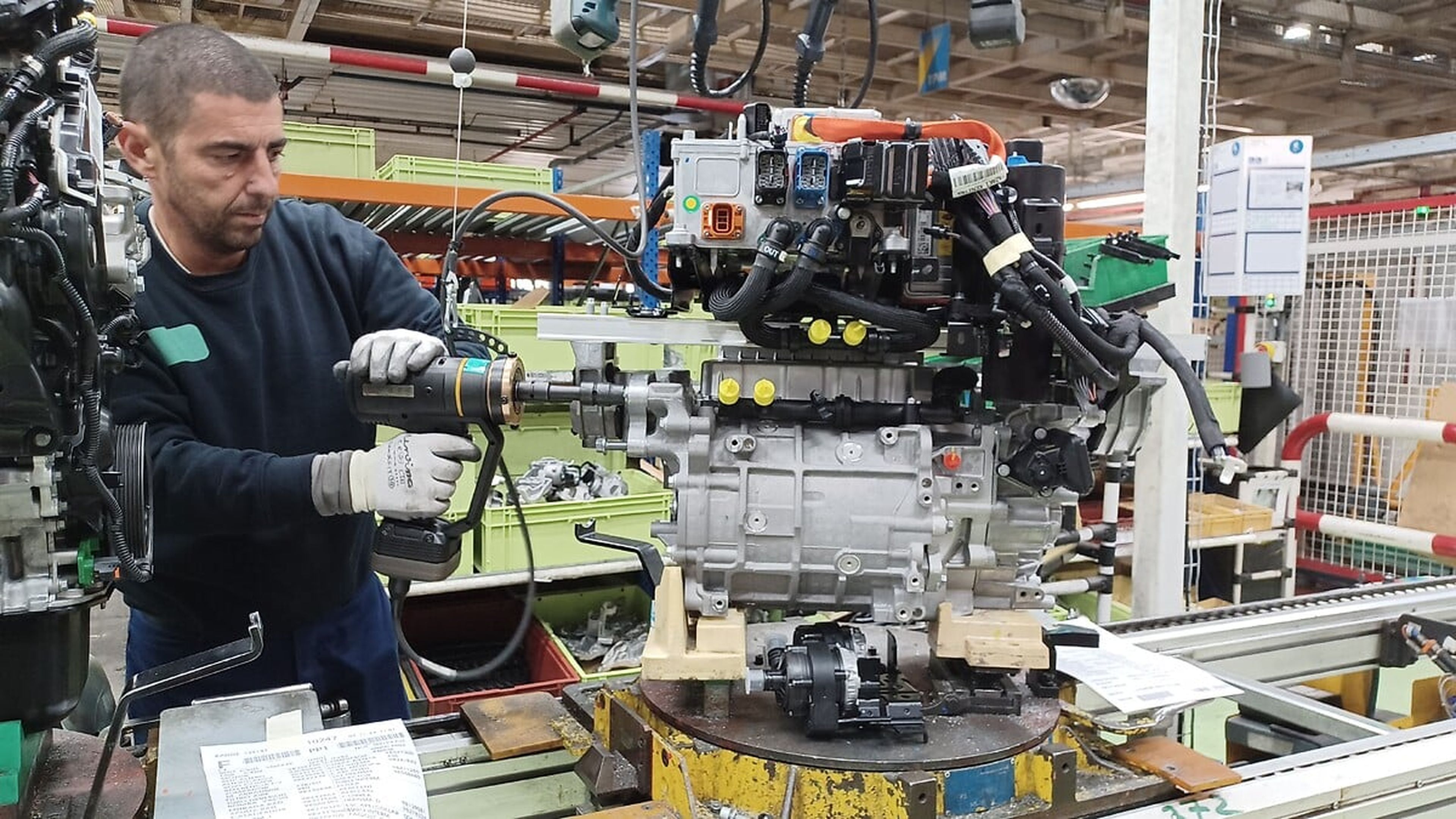 Un hombre trabajando en el motor del Citroën e2008. 