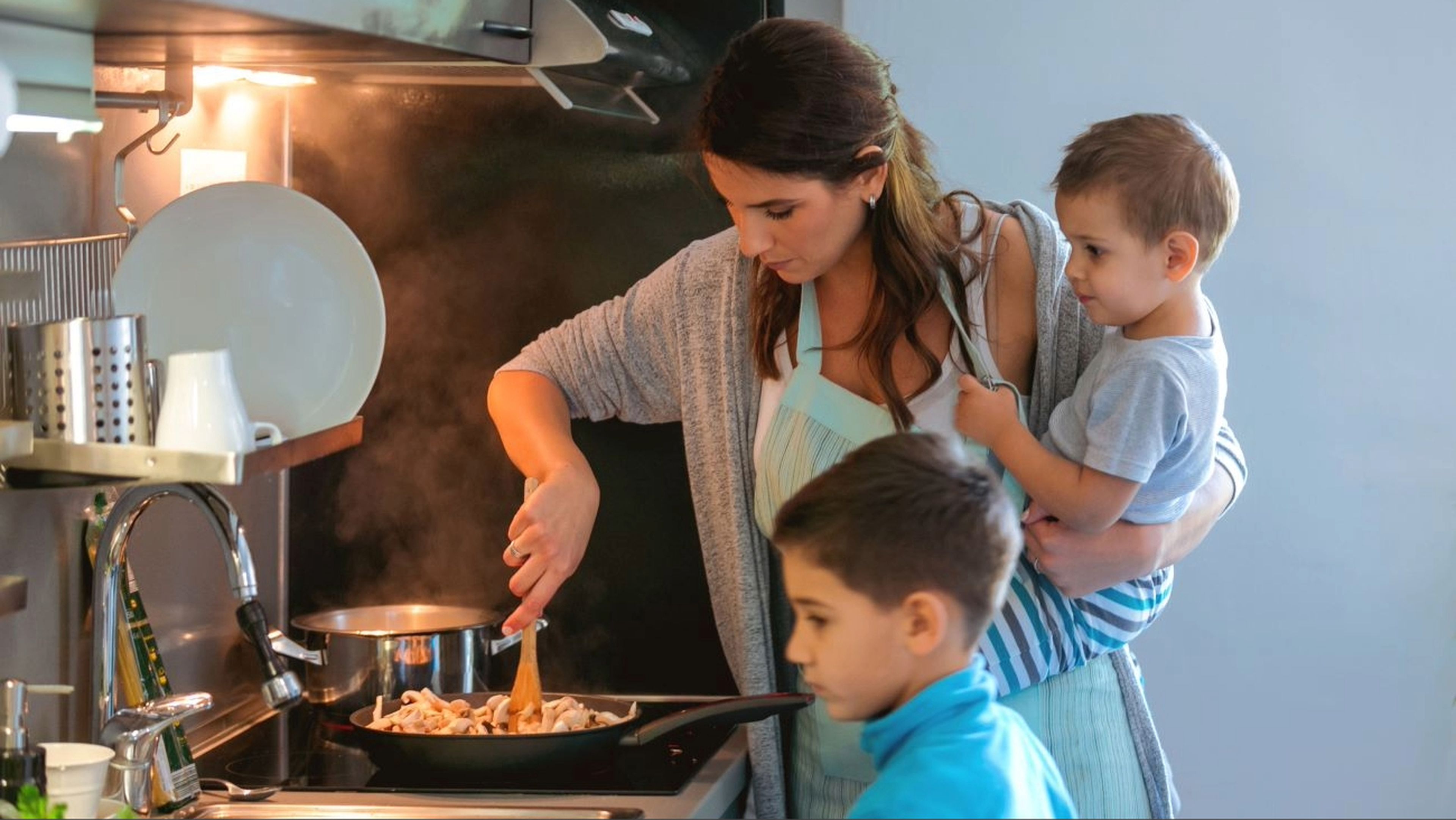 Madre con dos hijos, en la cocina de casa, familia monoparental