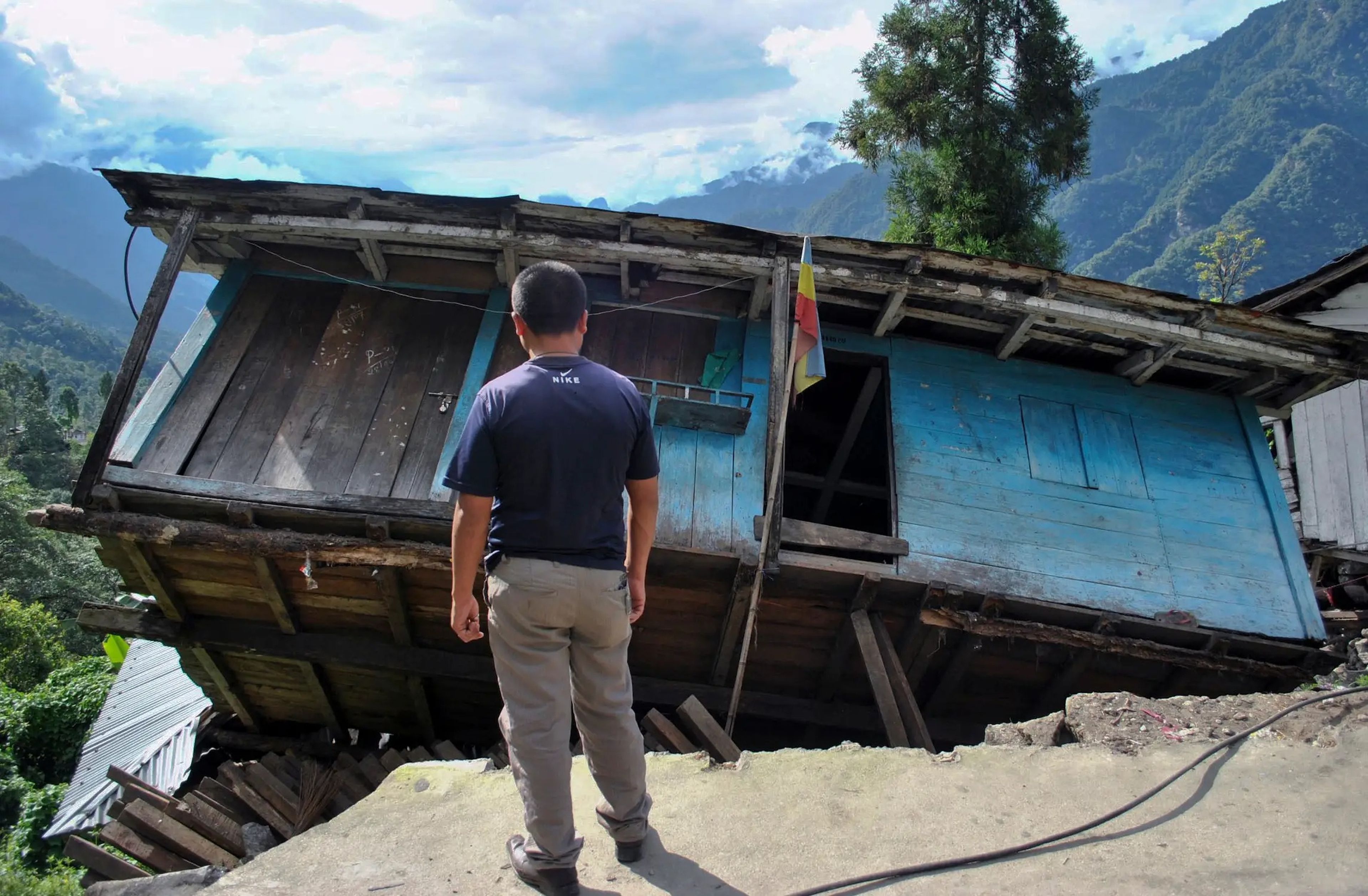 Un hombre frente a su casa, dañada por un terremoto de magnitud 6,9, en el pueblo indio de Mangan, en el Himalaya.