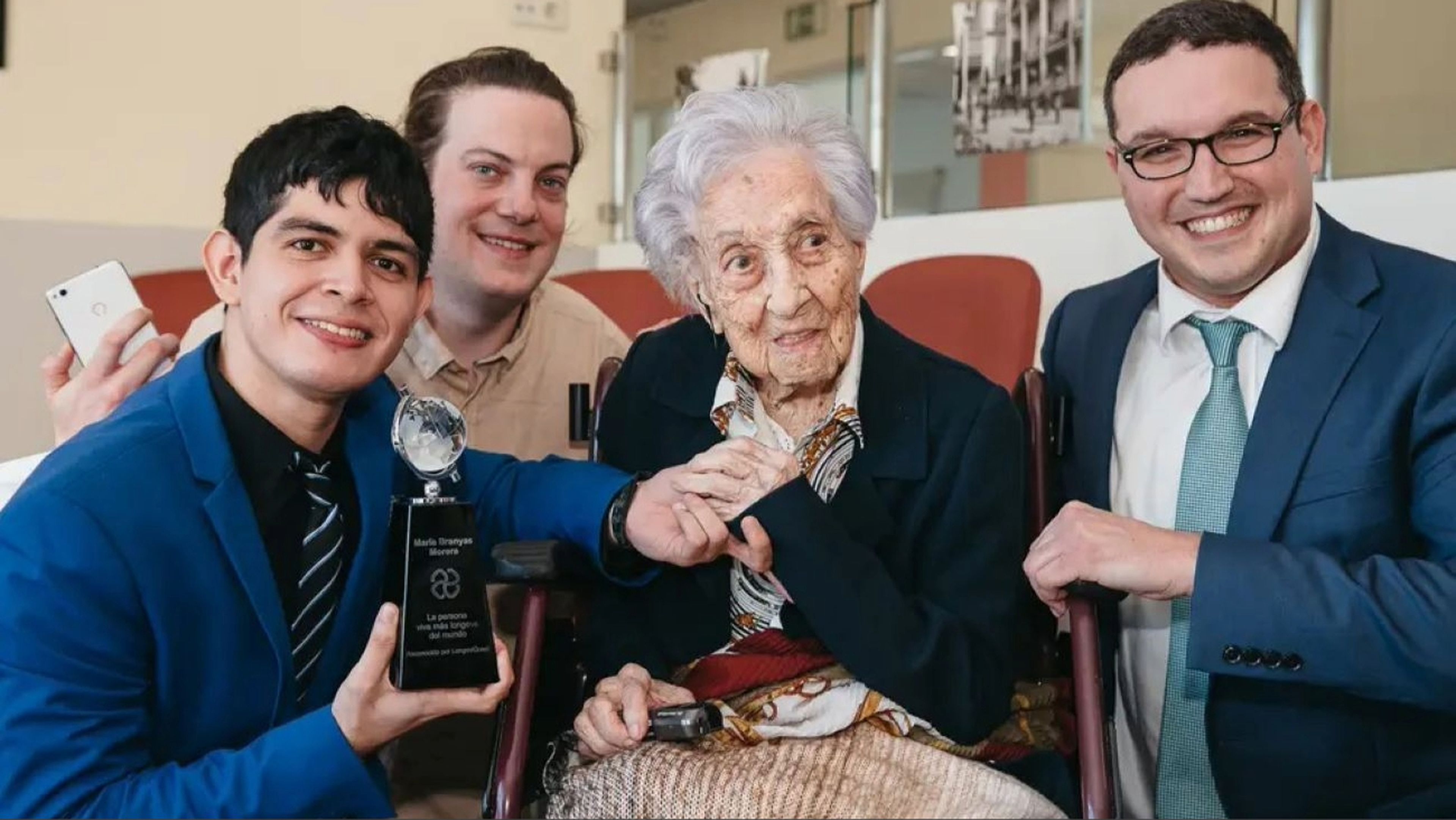 Fabrizio Villatoro (izquierda) y Ben Meyers (derecha) con María Branyas Morera, la persona viva más anciana.