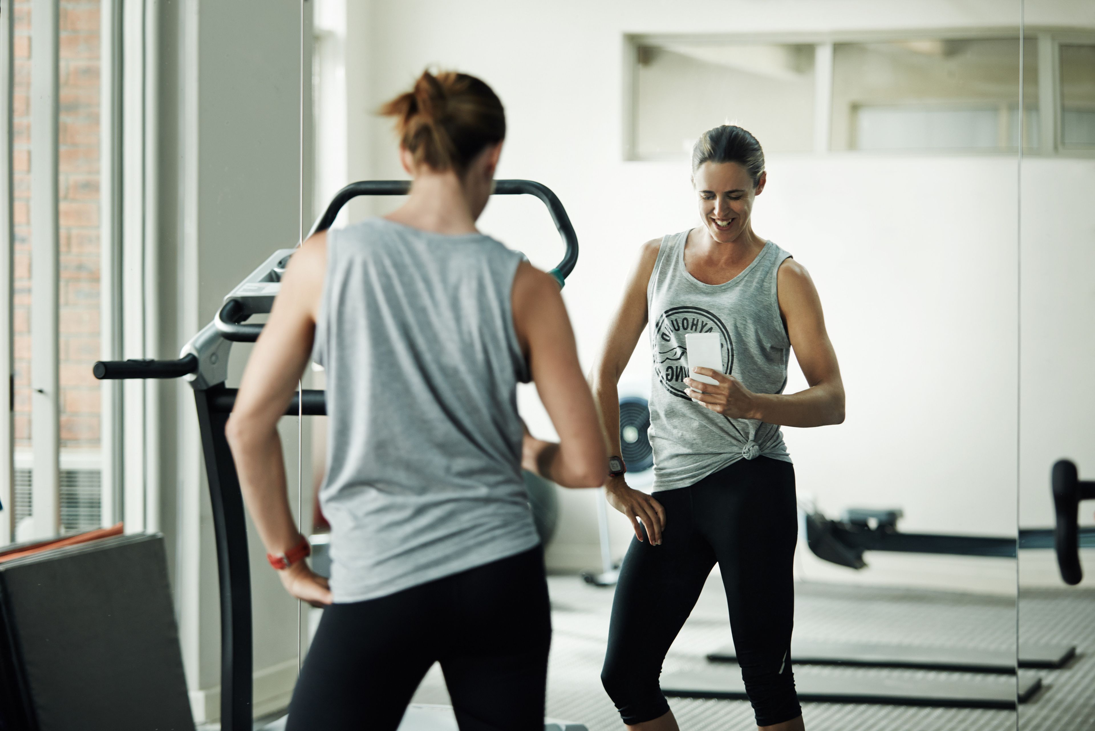 mujer mirándose en espejo en el gimnasio, ejercicio