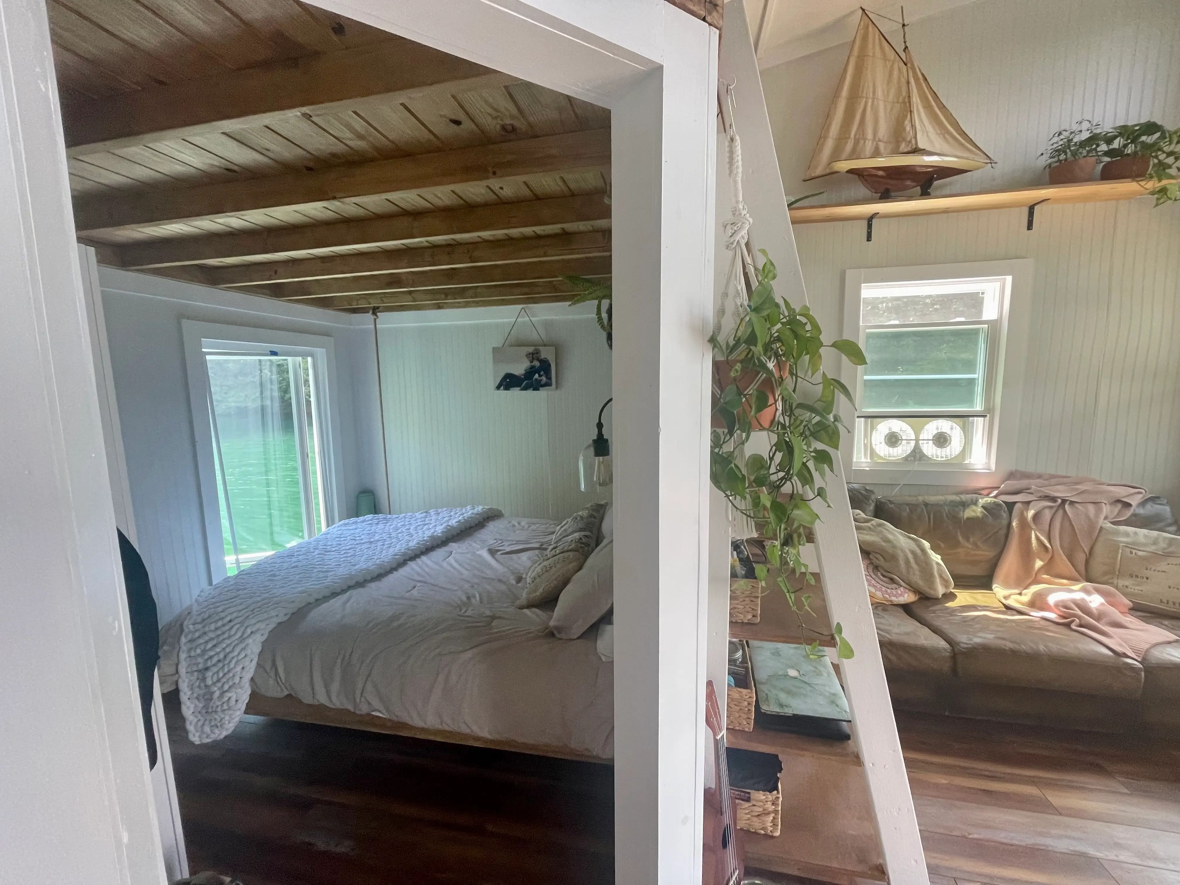An overview of the bedroom and the living room of the floating house. Both rooms are separated by a partition wall.