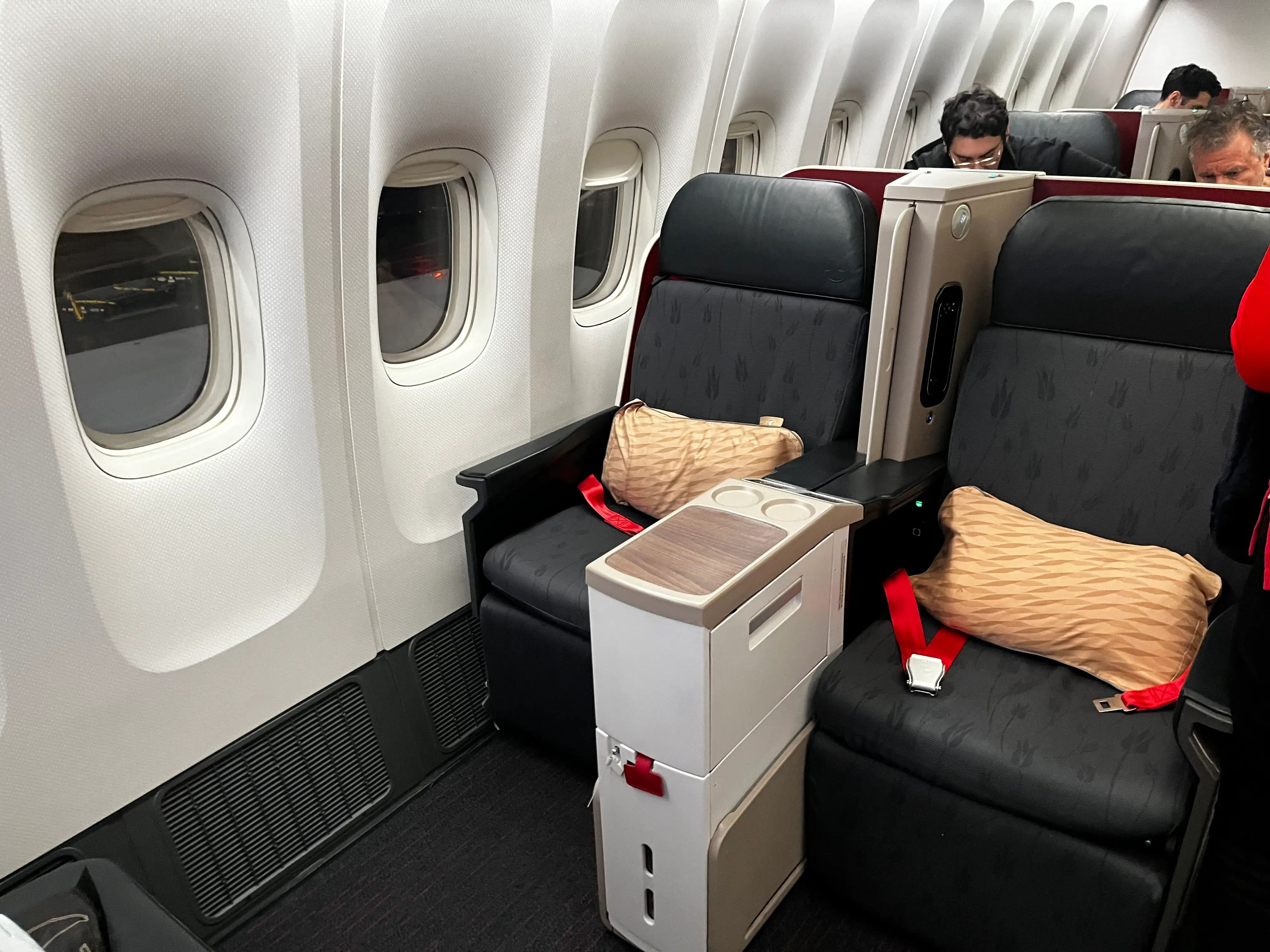 Pair of business class seats, with yellow pillows and a divider between them, on a Turkish Airlines flight