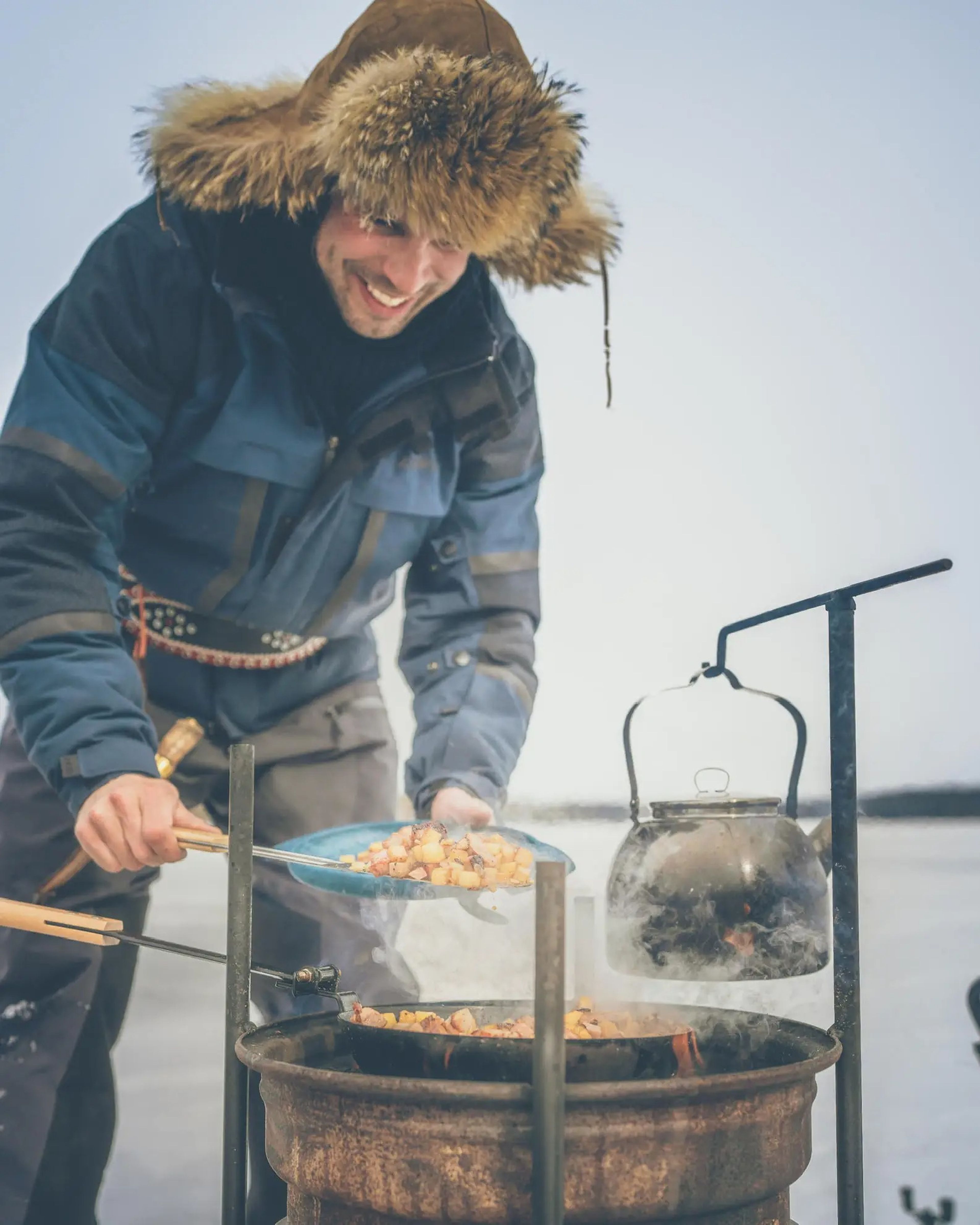 Petri Kokkonen cooking food in the Finnish wilderness.