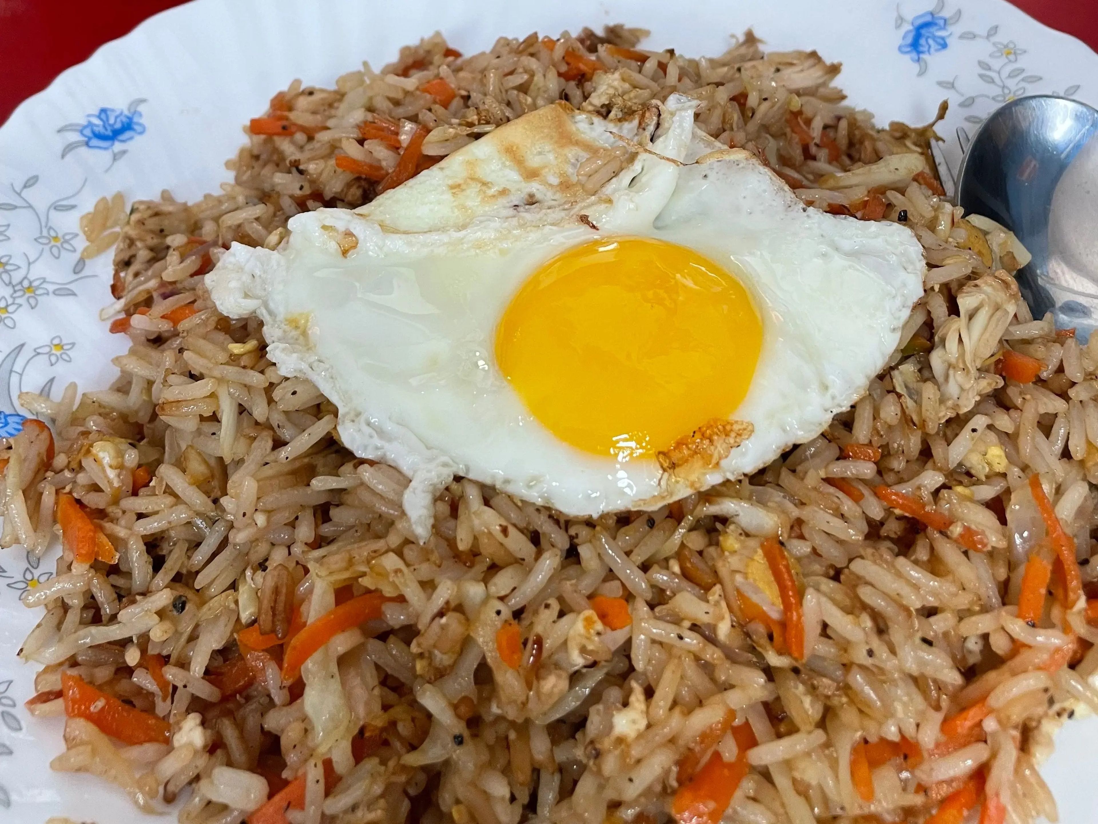 A plate of rice with a fried egg on top.