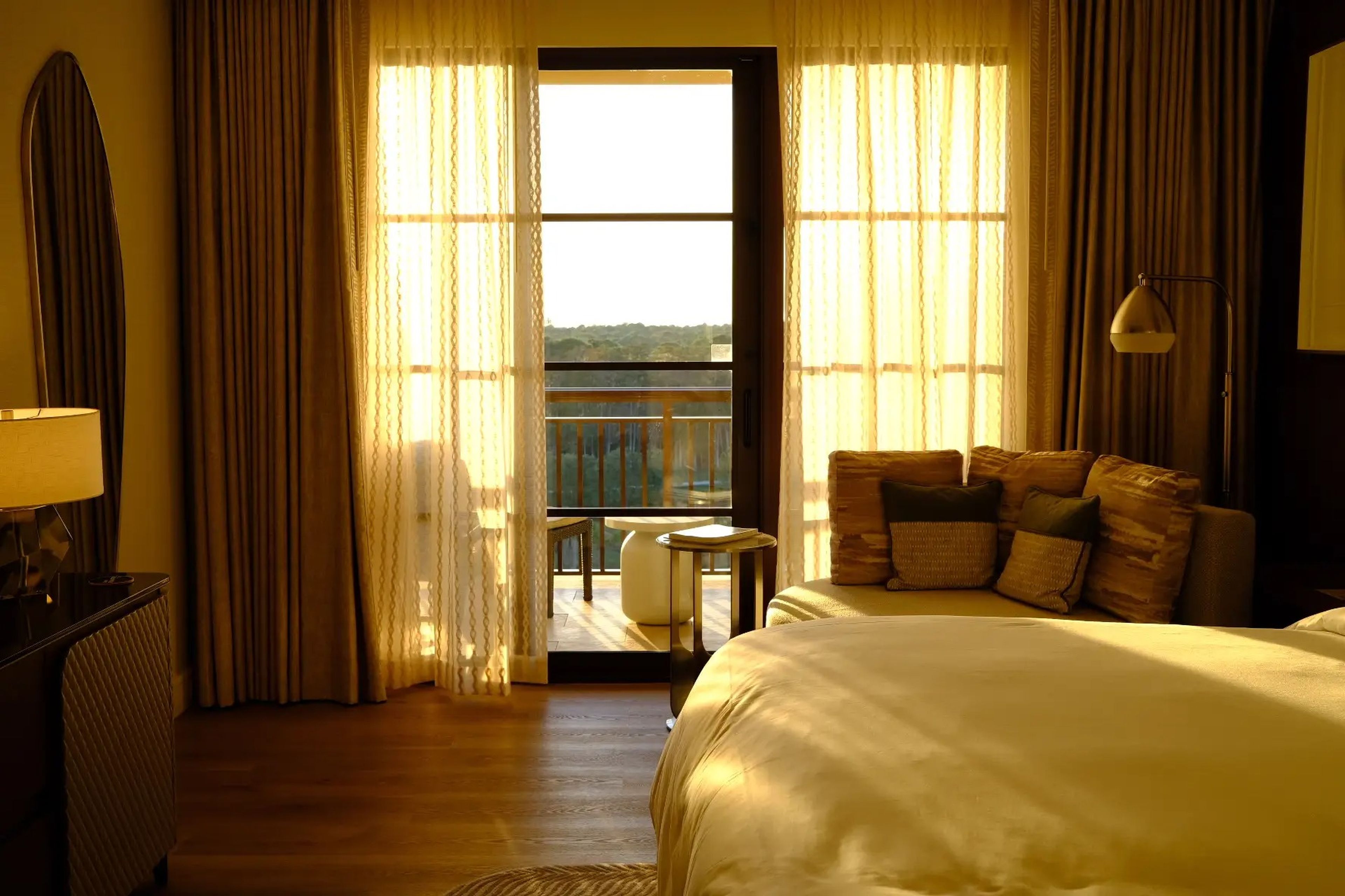 View of Disney World Four Seasons balcony with sun coming through semi-sheer curtains 