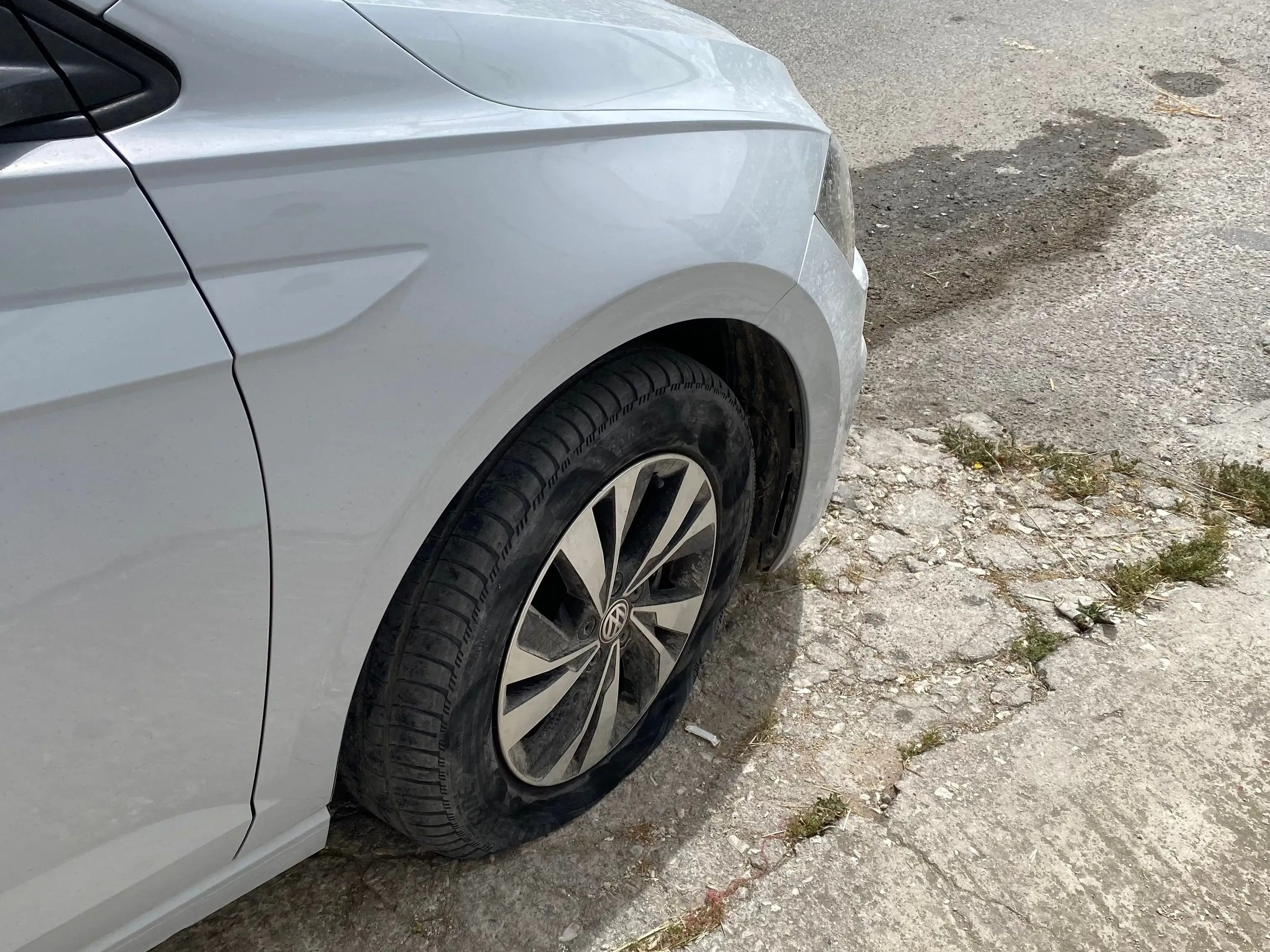 car with a flat tire on a paved road