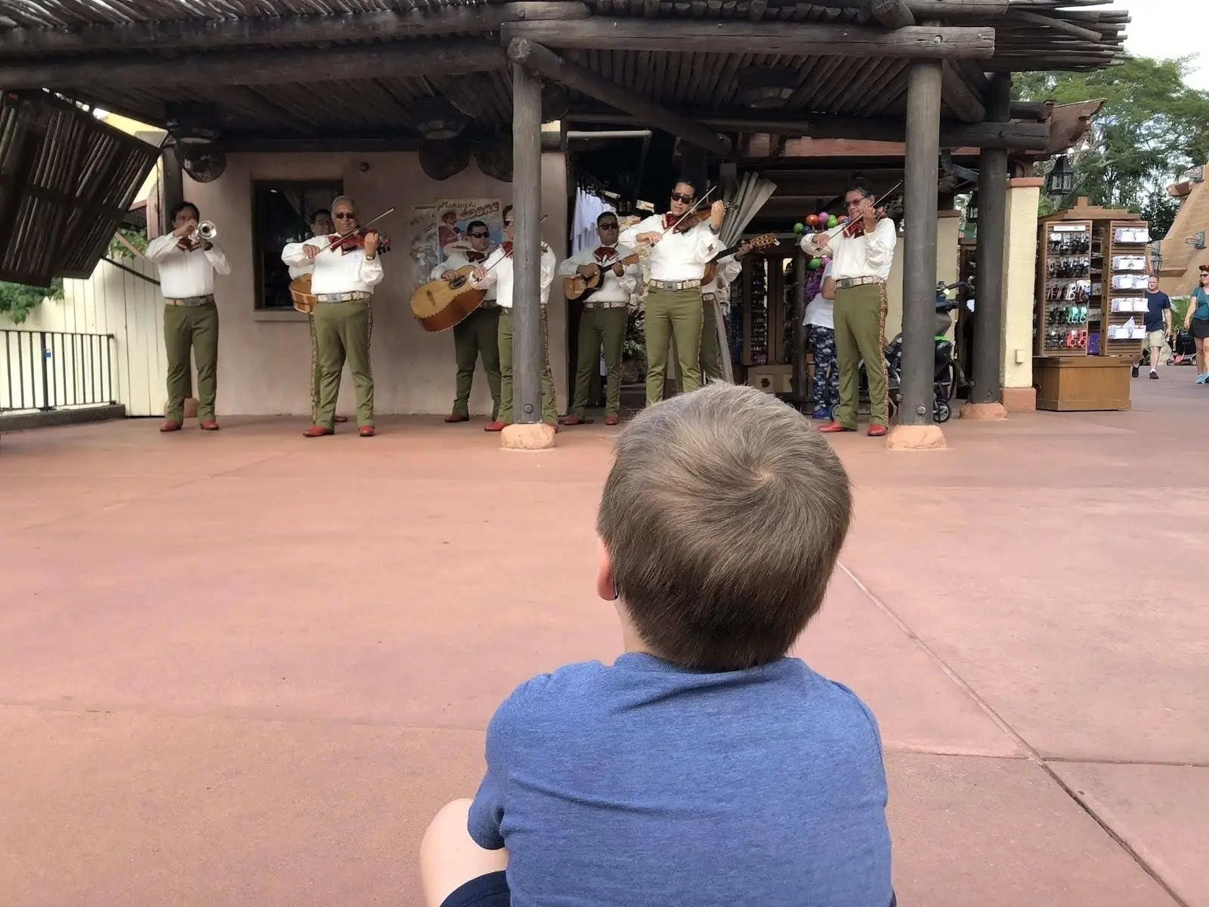 child sitting watching a performance in epcot's world showcase at disney world