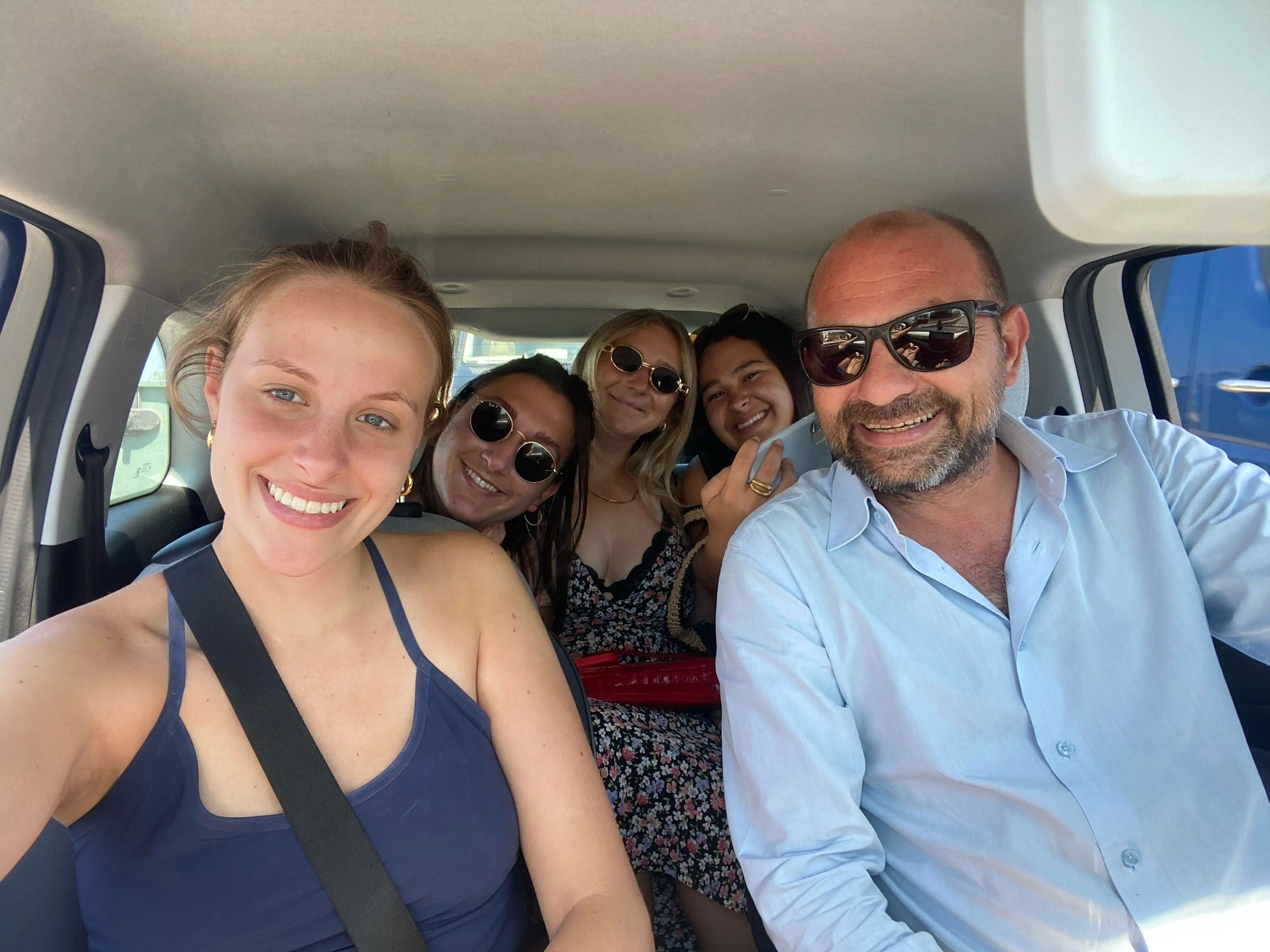 jordana and her friends taking a selfie in a car with their airbnb host