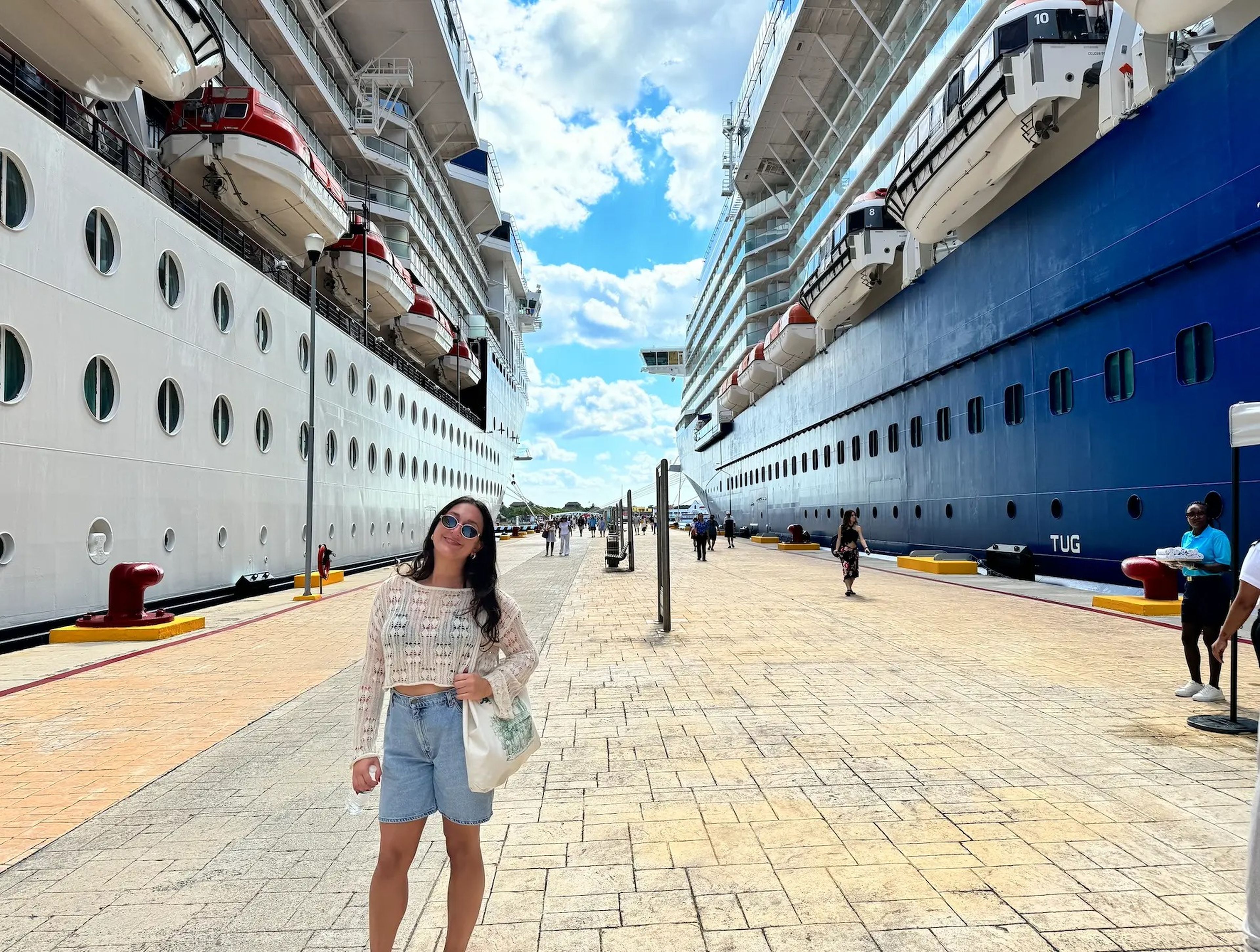 Jordana Comiter posing on a port in between two docked cruise ships