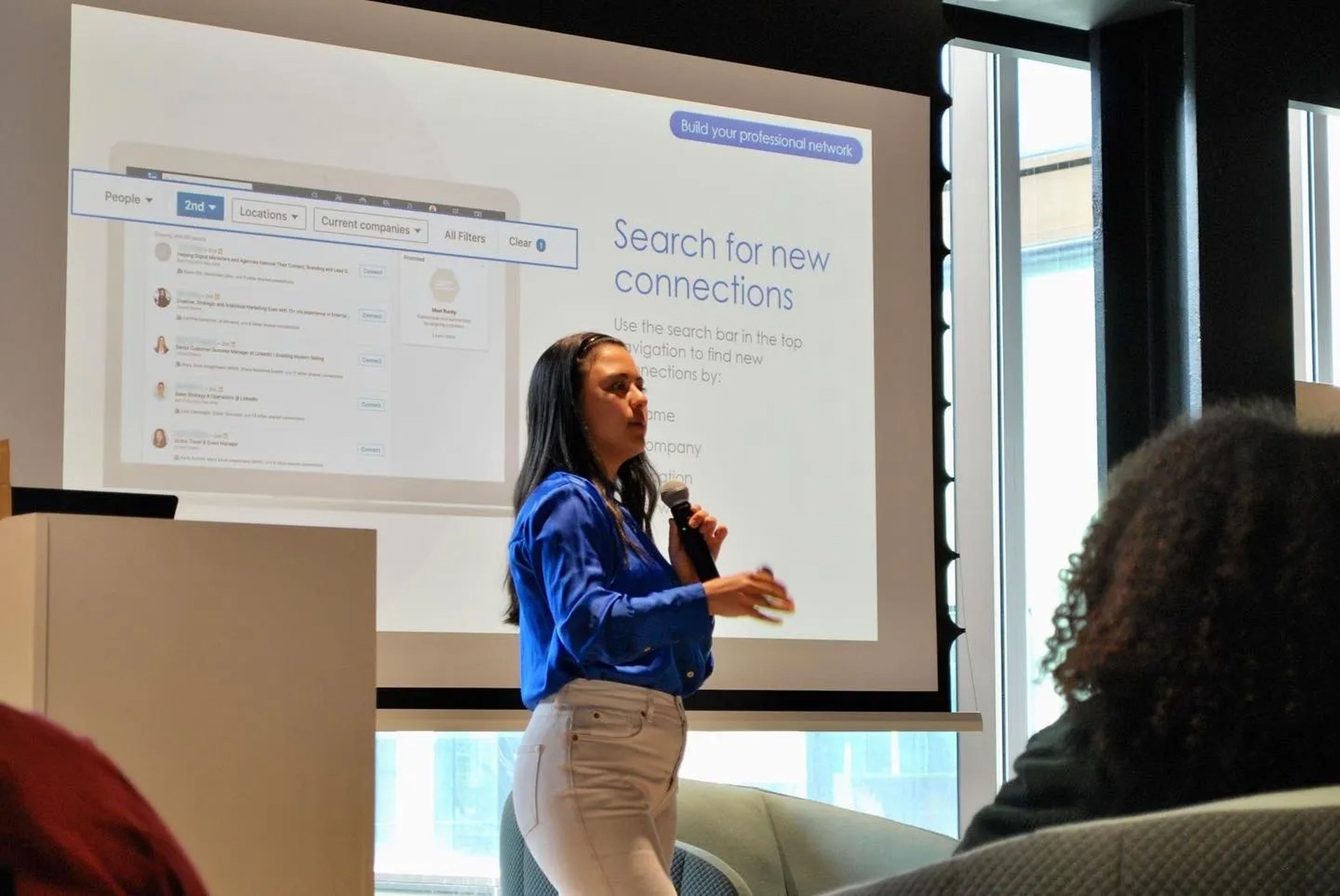 Mariana Kobayashi giving a presentation in front of a slide showing LinkedIn