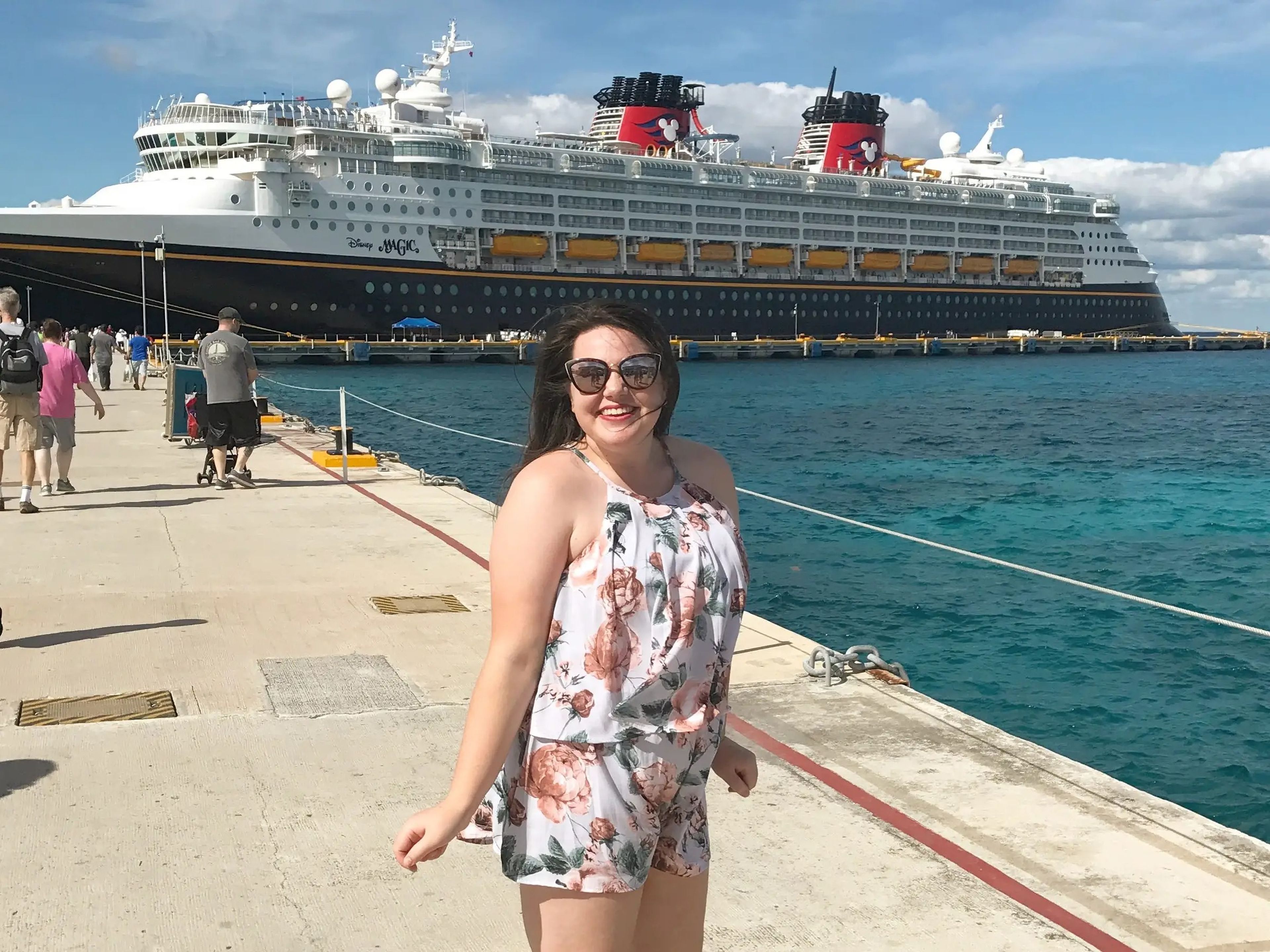 megan posing in front of a cruise ship at a port