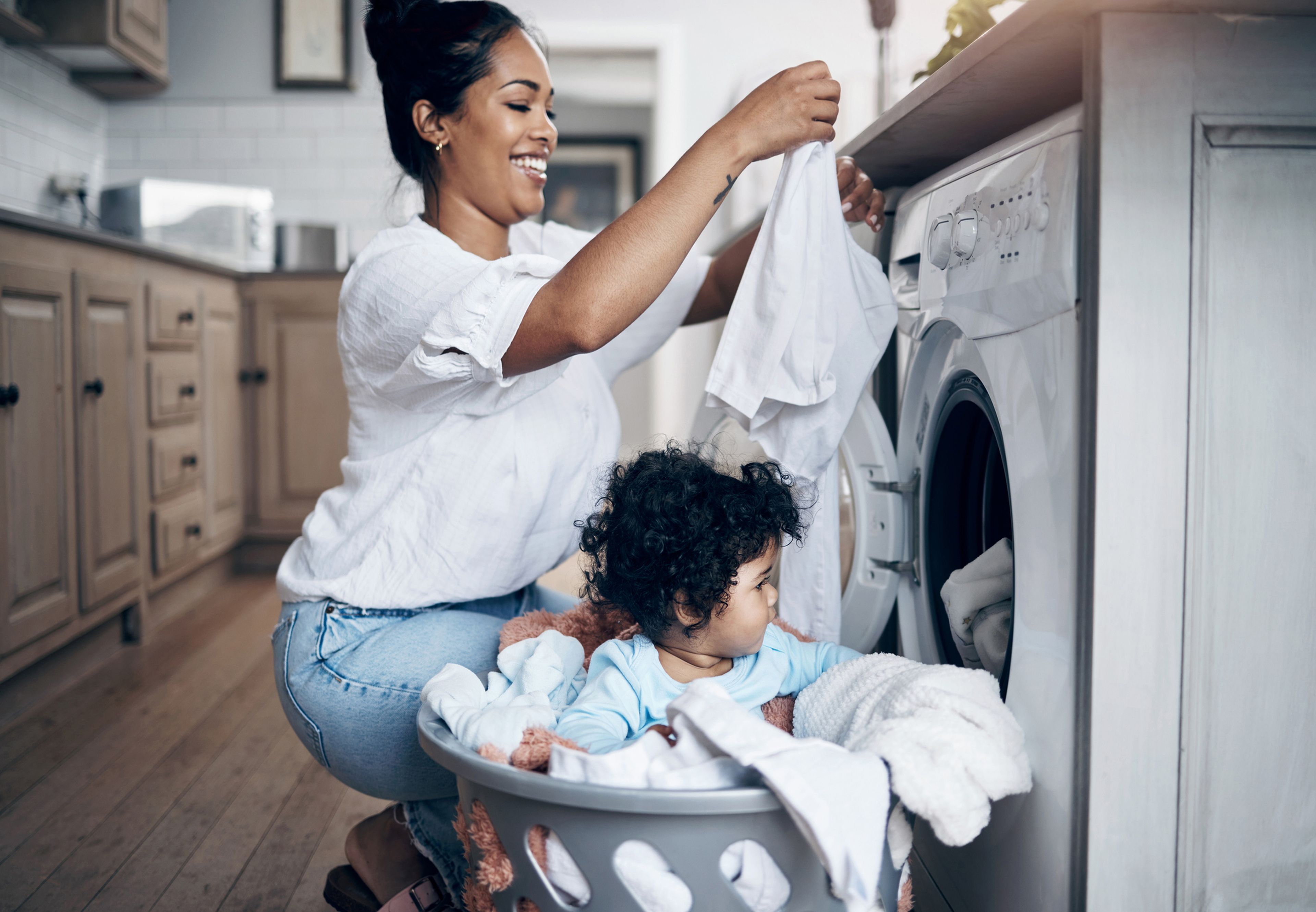 Mujer con su hija metiendo ropa en la lavadora