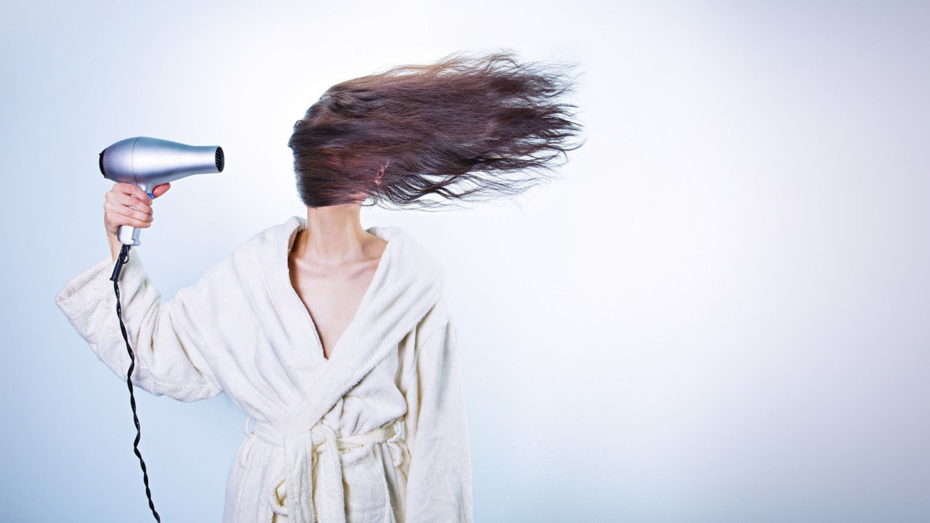 Una mujer se seca el pelo.