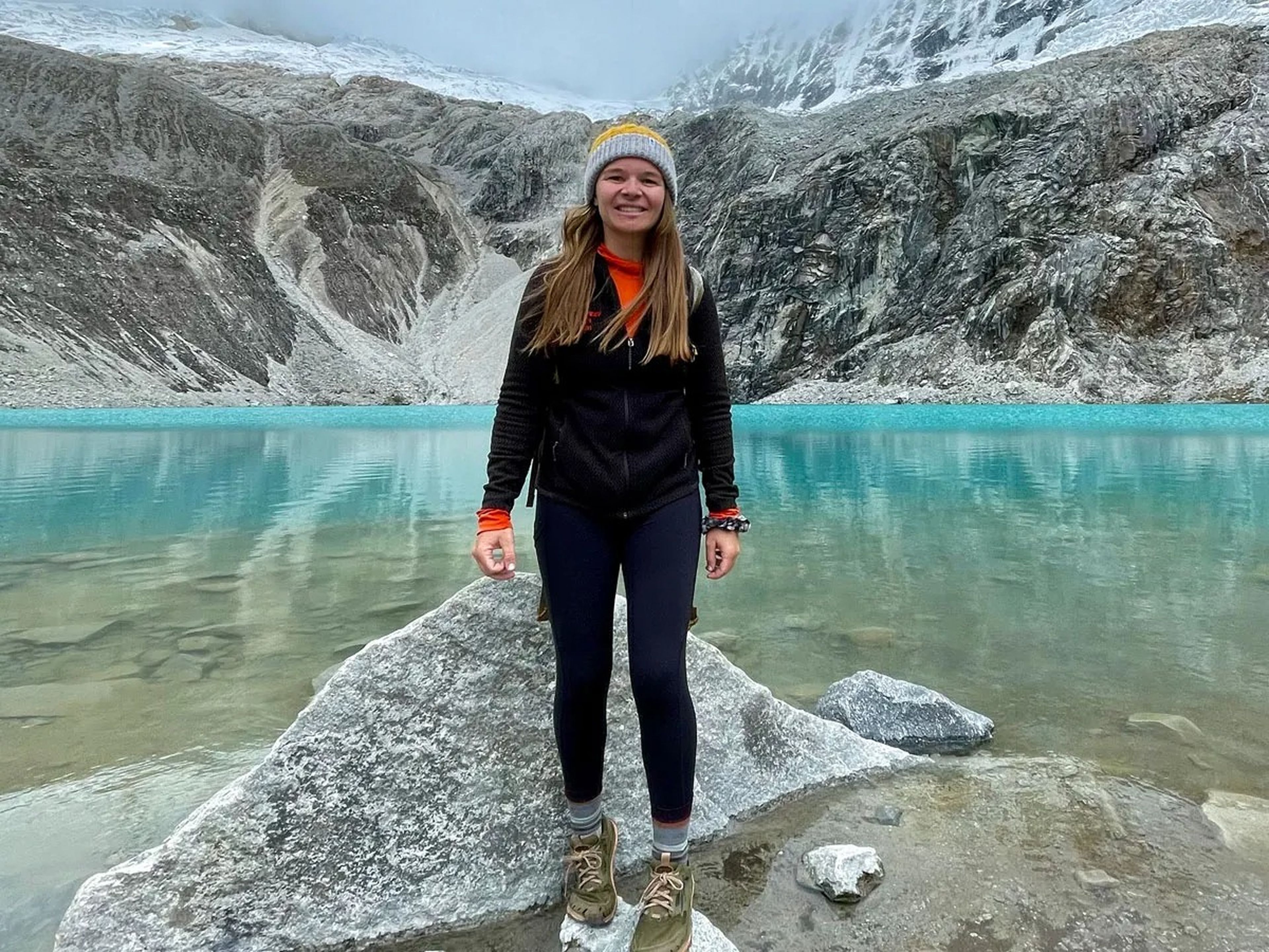 Nicole Jones standing in front of clear blue lake and mountains behind her