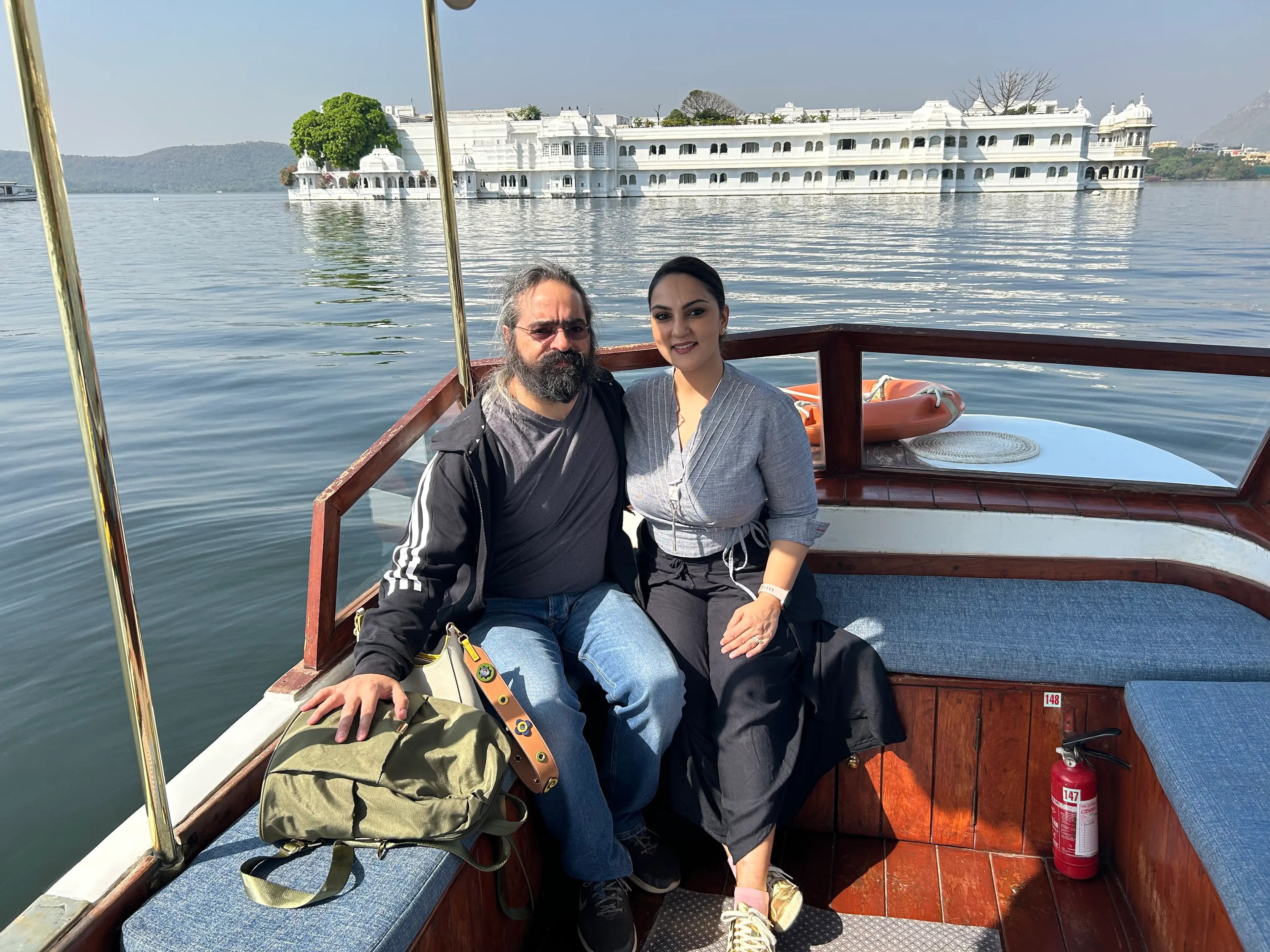 Noor and her husband pose on a boat in front of the Taj Lake Palace hotel.