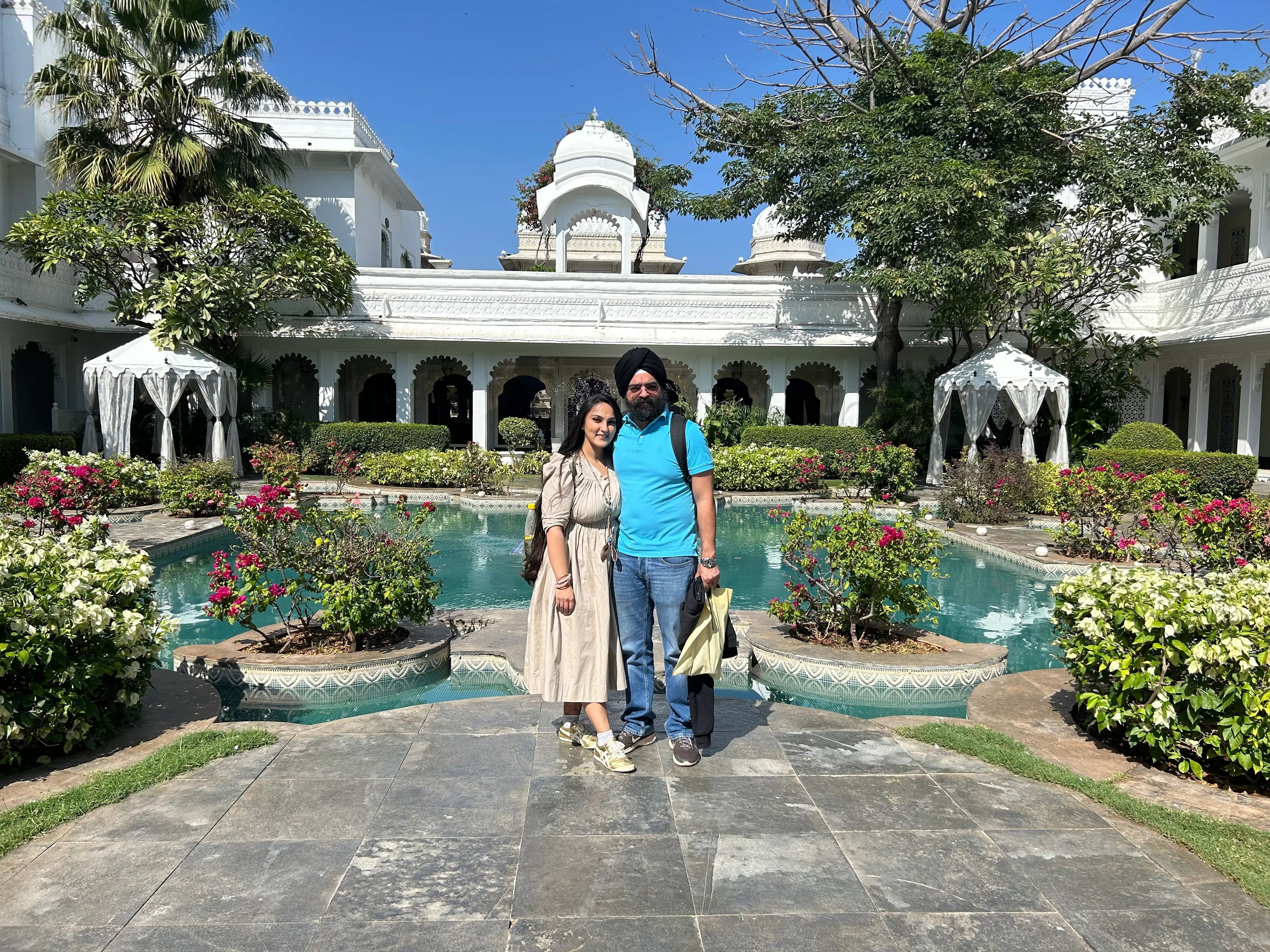 Noor and her husband pose in the central courtyard, which has a man-made pond and a garden.