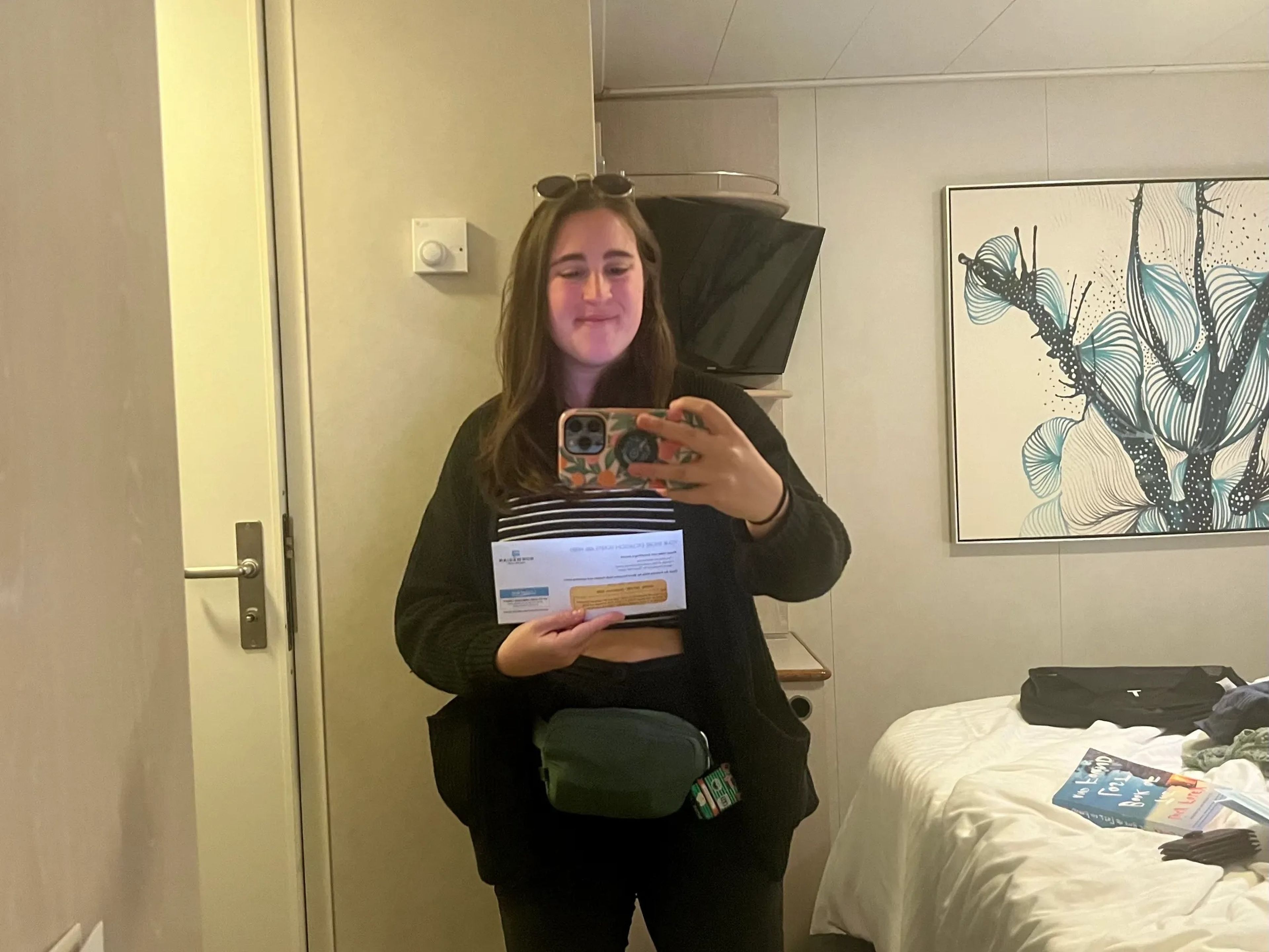 A picture of the author in the mirror holding excursion tickets.