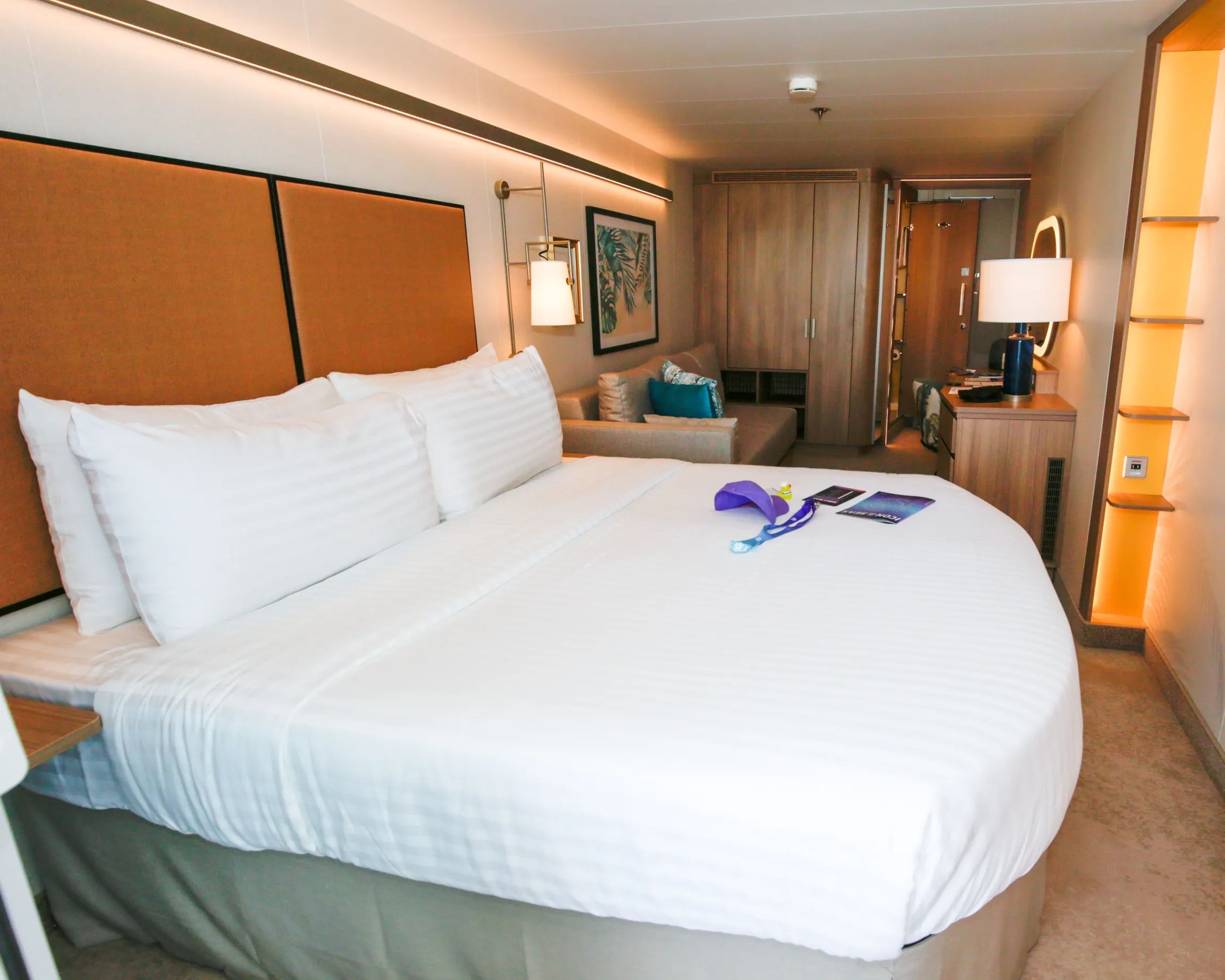 Royal Caribbean Icon of the Seas' ocean-view balcony cabin's bed and living room