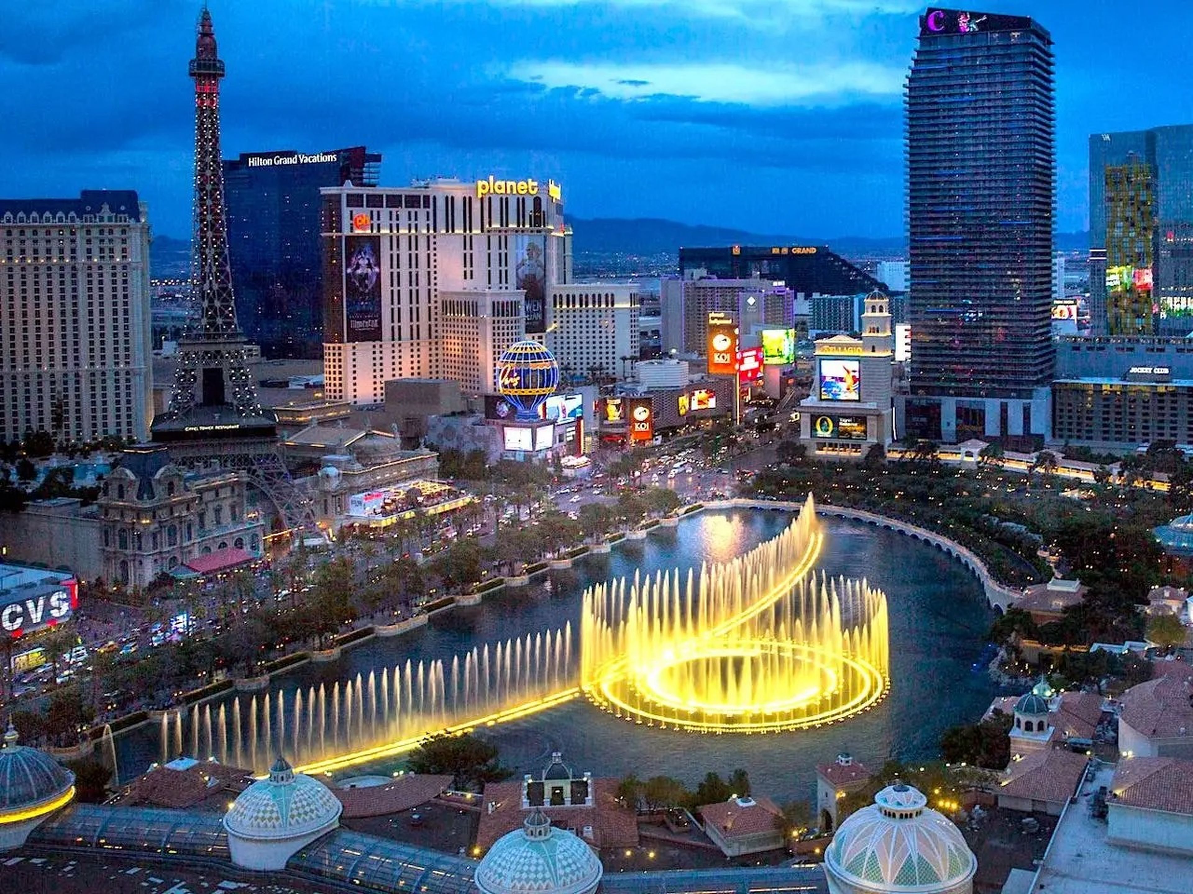 El espectáculo nocturno de la fuente de agua del Hotel Bellagio se puede ver entre las luces de otros casinos del Strip de Las Vegas.