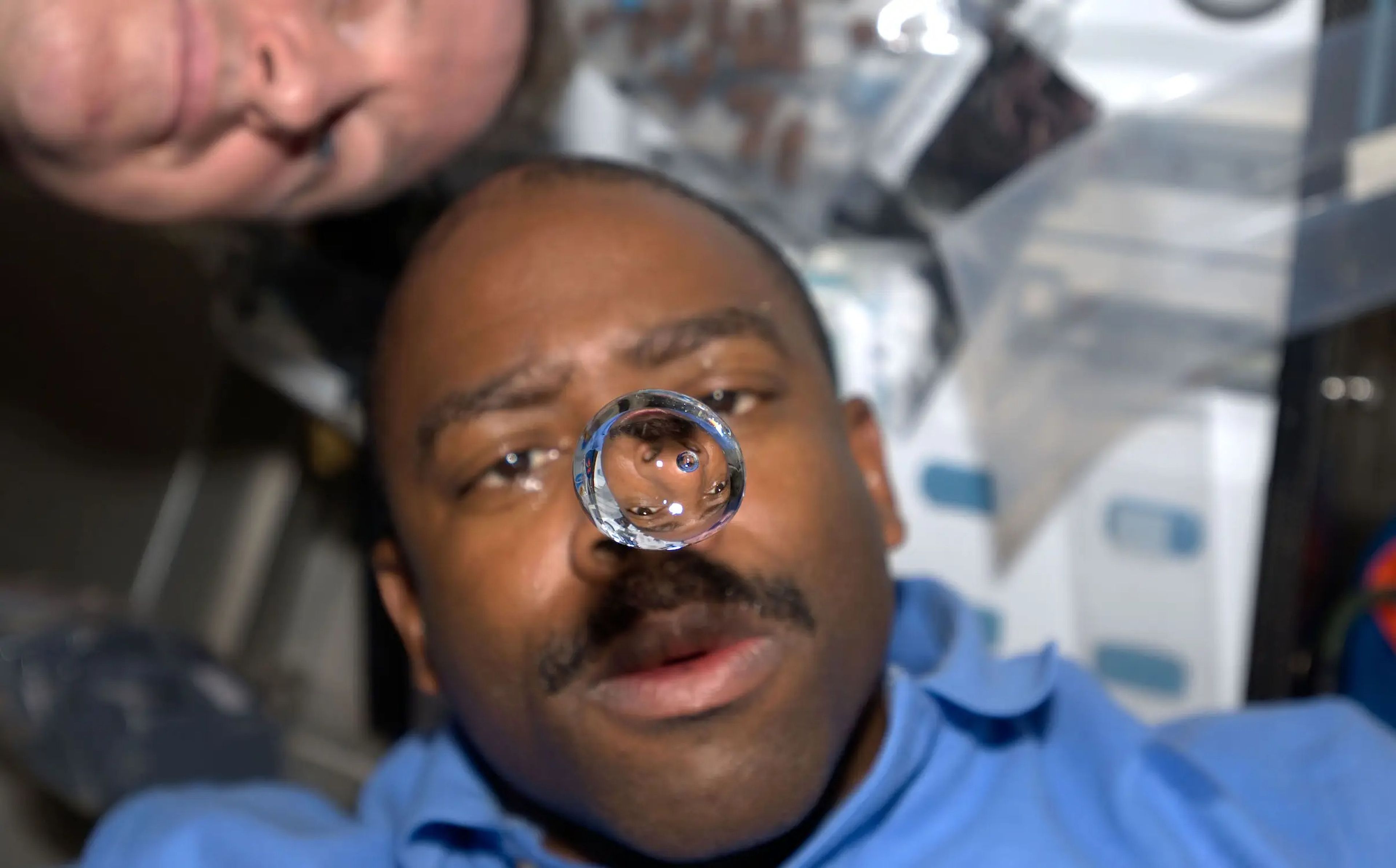 Astronaut Leland Melvin observes a bubble of water floating in the center deck of the space shuttle Atlantis.