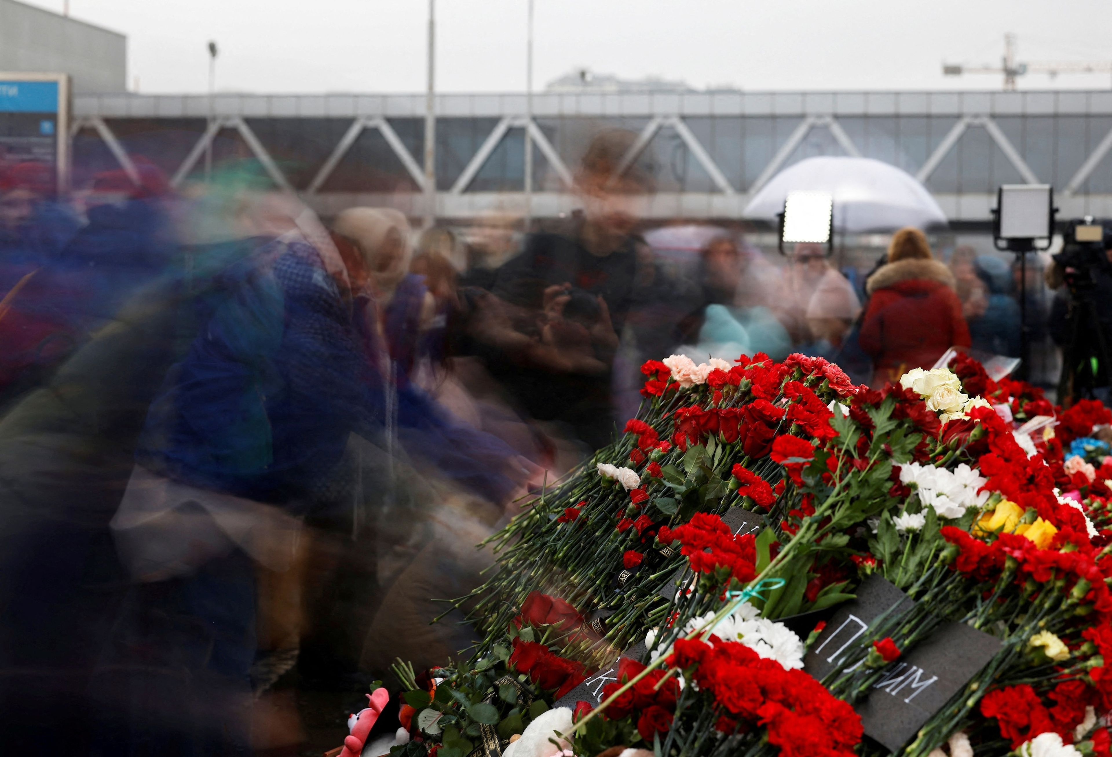La foto del día: Un grupo de personas deposita flores en un monumento improvisado en memoria de las víctimas del atentado de la sala de conciertos Crocus City Hall de Moscú, en el que han muerto más de 130 personas.
