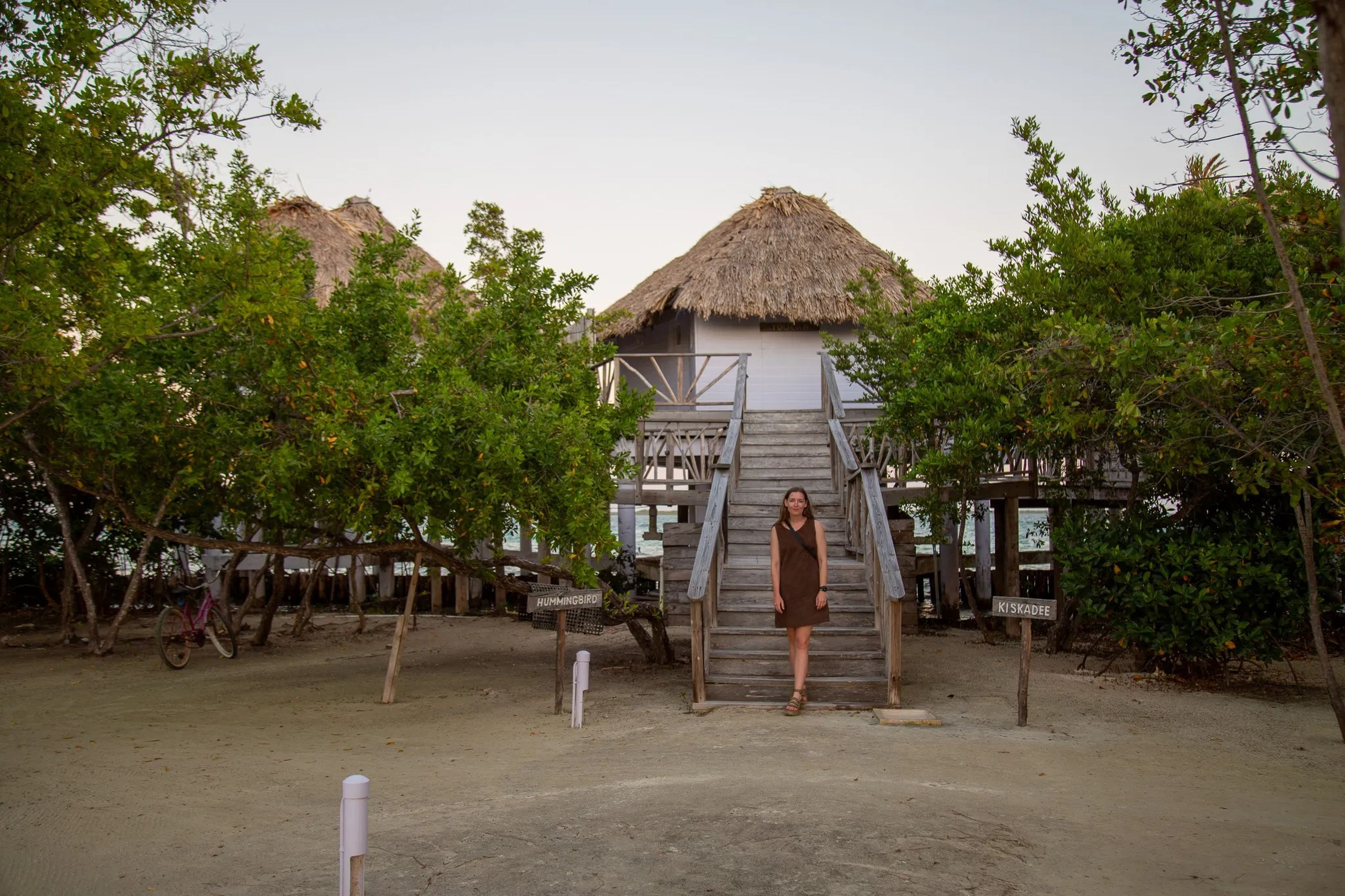 The author stands in front of bungalows at the Thatch Caye resort in Belize.