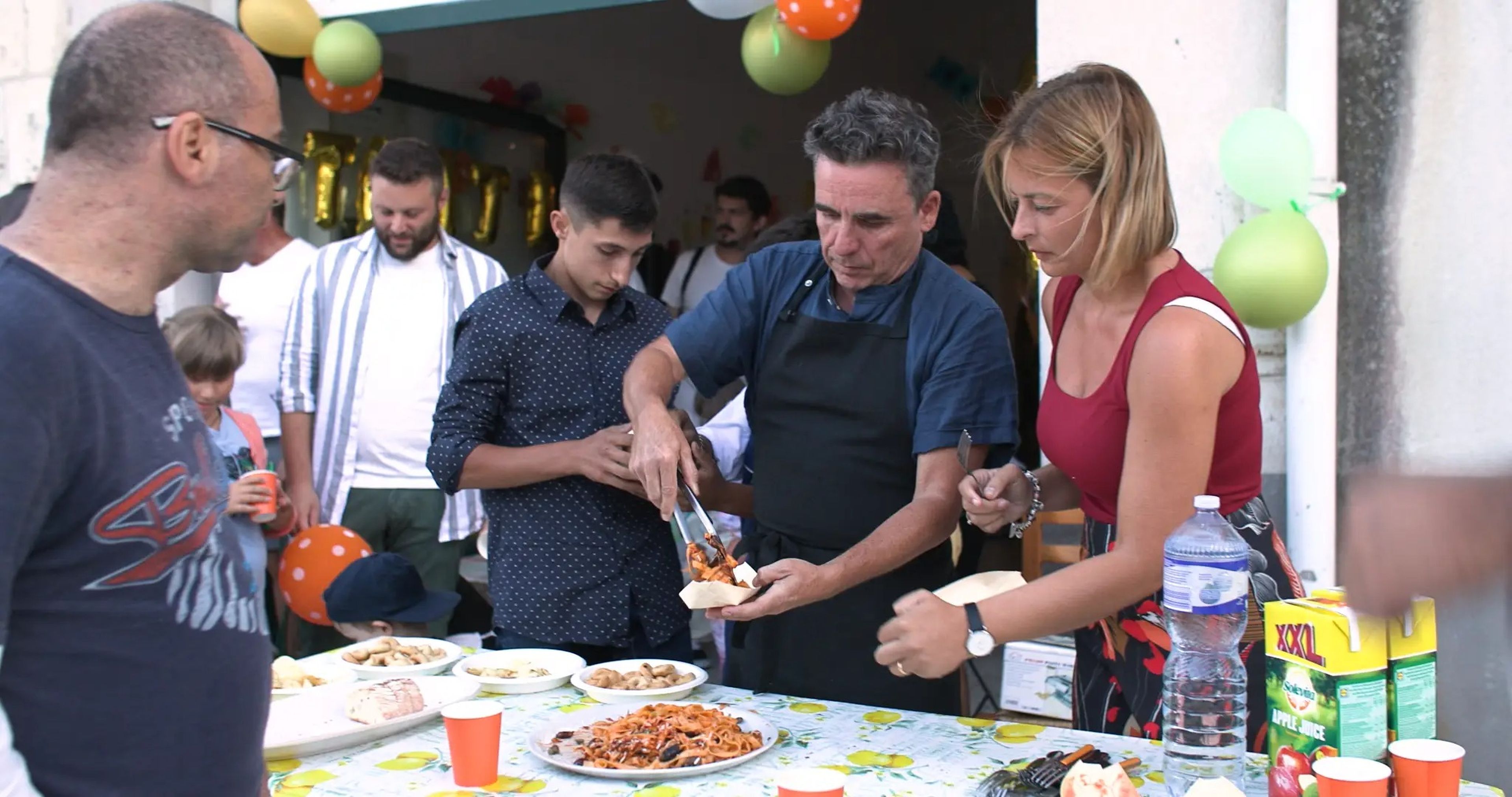 Danny McCubbin sirve pasta para celebrar los dos años de The Good Kitchen en Mussomeli, Italia.