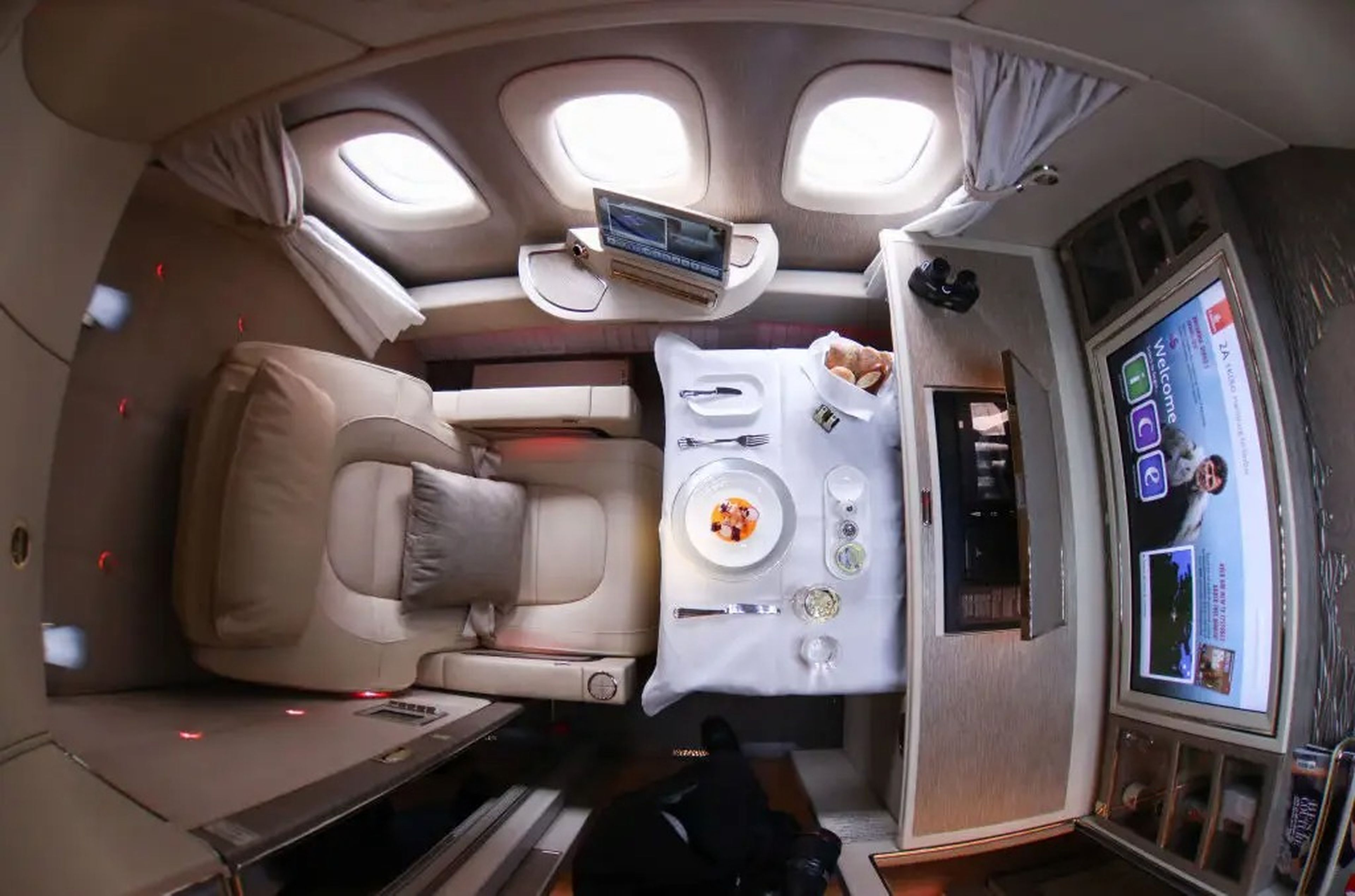 Servicio de comidas en el interior de una suite de primera clase de un Boeing 777 de Emirates.