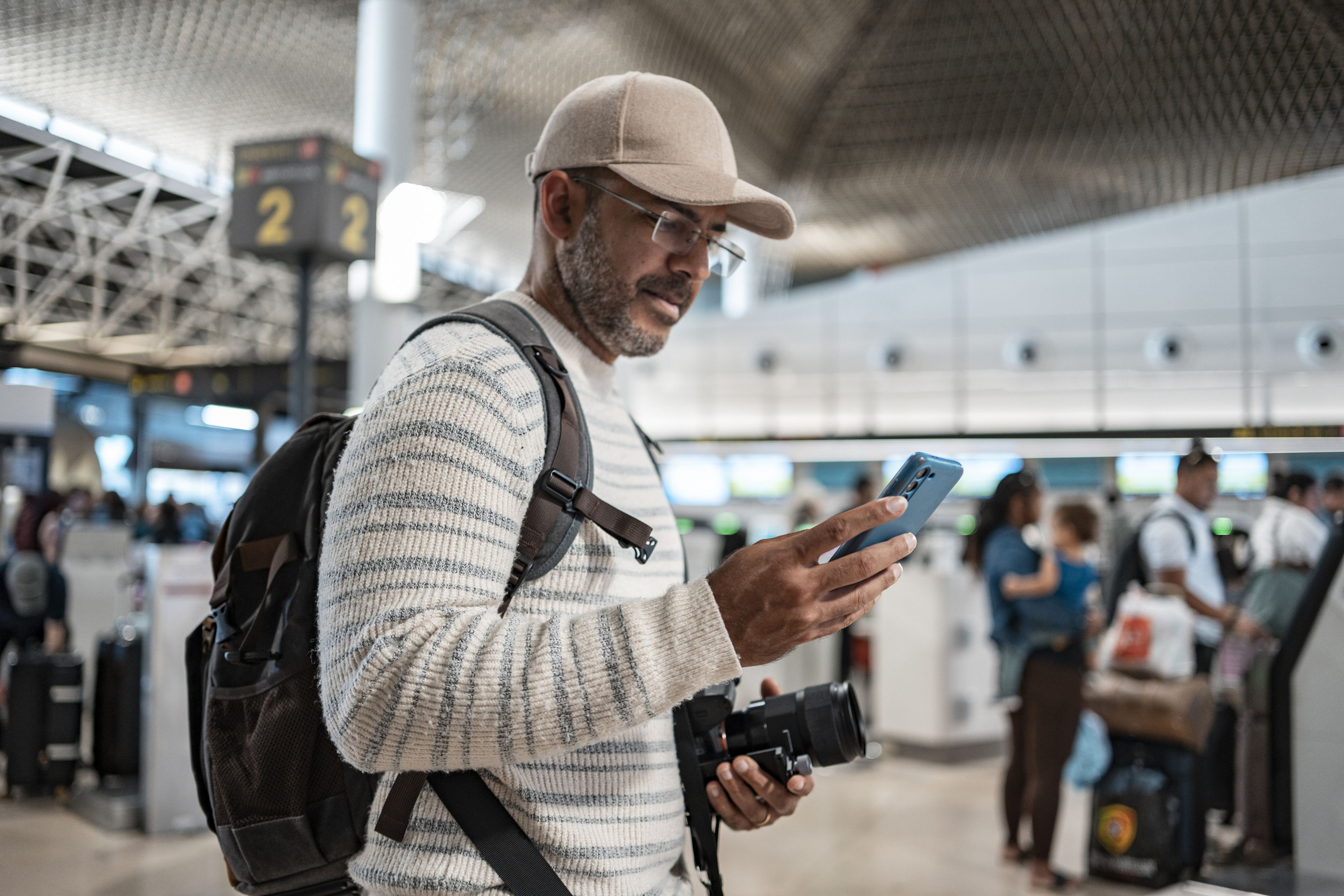 Hombre en un aeropuerto mirando el móvil
