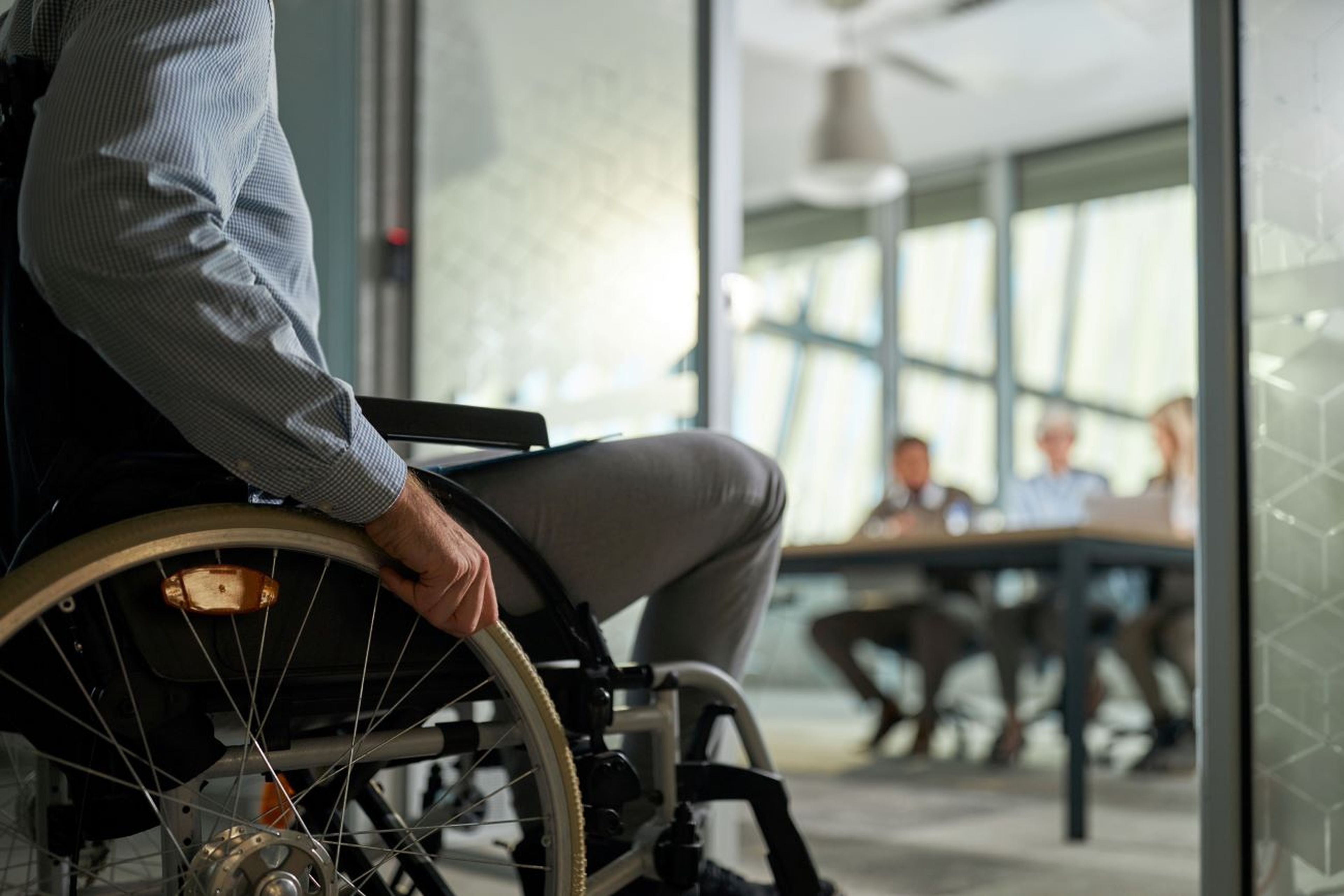 Hombre en silla de ruedas entra en oficina de trabajo